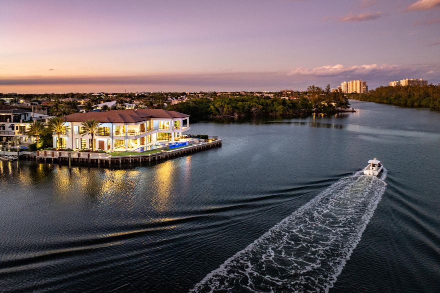 Introducing Trinity Point Estate, a one of one waterfront compound in Boca Raton, now presented for the first time ever. Positioned on an extraordinary point lot with 368 feet of water frontage, the estate captures sweeping Intracoastal views spanning the East, South, and North exposures, delivering true 360 degree water vistas from nearly every room. Spanning approximately 14,000 square feet, this newly constructed residence was designed with a focus on scale, privacy, and seamless indoor outdoor living. Every space is thoughtfully oriented to maximize natural light and frame the surrounding water, creating a constant connection to the outdoors.   The home features a 2,000 square foot primary suite, offering a private retreat with expansive water views, oversized dual closets, and a spa inspired bath. Additional highlights include a fully built out gym, private elevator, multiple guest suites, and expansive living and entertaining areas finished with the highest level of craftsmanship. At the center of the outdoor experience is a dramatic see through infinity edge pool designed by Lucas Congdon of Insane Pools, perfectly positioned to overlook 368 feet of unobstructed Intracoastal frontage, creating a true resort style setting. Enhancing the backyard experience is a 75 inch pop up outdoor television integrated into the patio deck, rising to frame the jacuzzi, an ideal setting for relaxed evenings and watching sports in a resort style environment. The chef's kitchen is anchored by Eggersmann German cabinetry and a curated suite of Gaggenau, Sub Zero, and Miele appliances, complemented by a full Kalamazoo outdoor kitchen featuring a professional grade BBQ, gas cooktop, and pizza oven. Built to a commercial standard rarely seen in residential construction, the estate includes a MEI commercial grade elevator with a 2,500 pound capacity, a 100KW Generac generator, Lennox variable speed HVAC systems, and full home Control4 automation. The residence is further enhanced by Level 5 drywall throughout, Fleetwood impact glass and sliding doors, closed cell insulation across all exterior walls, and a fully waterproofed building envelope, delivering exceptional efficiency, durability, and storm resilience. Wellness and lifestyle features include a Sunlighten infrared sauna, whole house triple water filtration system, advanced air and scent integration with Aroma360, and state of the art security with live virtual monitoring. Crafted with the finest materials and built to the highest standards of sustainability, Trinity Point Estate blends timeless design with modern innovation, offering one of the most significant and thoughtfully executed waterfront residences in South Florida. This is more than a residence, it is a landmark property.