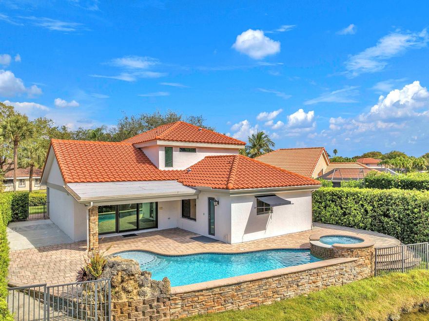 Beautiful former model home featuring 4 bedrooms and 2.5 bathrooms. The updated kitchen offers deluxe cabinetry and top of the line stainless steel appliances, including a smart refrigerator. The primary suite is conveniently located on the ground floor, with three additional bedrooms upstairs for added privacy. Travertine flooring enhances the main living areas. Enjoy stunning waterfront views, a heated pool and jacuzzi, covered patio and wrap around fenced terrace, Additional features include thermal impact windows and doors, six hard wired security cameras, ADT alarm system and a finished two car garage with treated flooring, cabinetry, and ample lighting. With too any features to list schedule a private showing today.