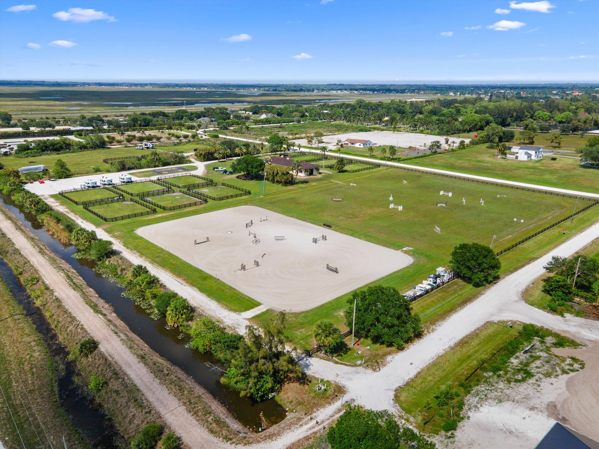 15 acres made up of 3 parcels. 5 acres mostly cleared and filled with fencing and water and electric, plus pads. RV hookups and spots10 acre farm with 15 stall barn, HUGE grass riding field, oversized JTWG ring w irrigation, paddocks w irrigation and water, 4 RV spots. There is room for absolutely anything you want here.
