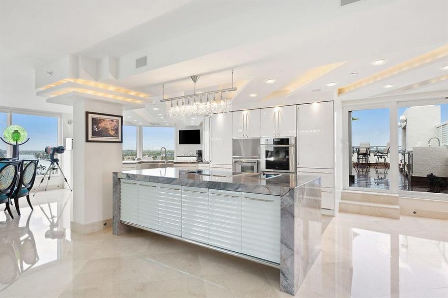 A rare find, this 4 BR, 4 1/2 bath luxury oceanfront , penthouse double unit is directly on the sand. Offering tremendous space, it occupies its own wing with 4,480 square feet under air. Spectacular, unobstructed 360 degree views of the ocean, Intracoastal, & city from the 1600 square foot roof top Ipe wood deck with built-in grill/summer kitchen, providing the perfect backdrop, whether entertaining large groups or capturing the endless water and brilliant sunrise-to-sunset vistas.The contemporary interiors offer custom high end finishes - including extensive use of marble flooring throughout, granite and glass, dramatic architectural lighting, Swarovski crystal fixtures, and an ultra modern chef's kitchen equipped with high end, built-in stainless appliances.On the first level