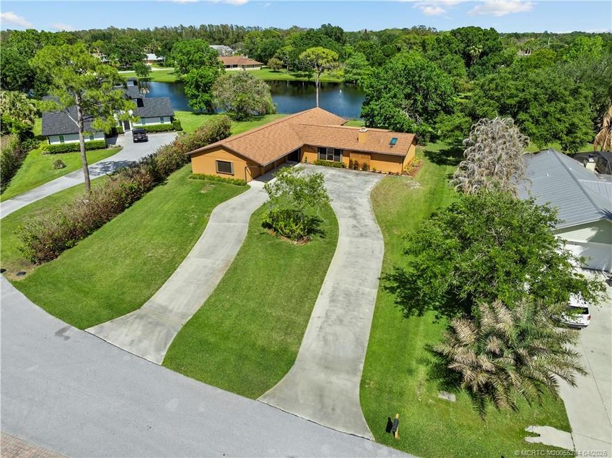 Lakefront living on over half an acre in the heart of Palm City within Canoe Creek Community! This ranch-style home, owned and meticulously maintained by its original owner and never before on the market, offers 5 bedrooms, 3 full baths, and a 3-car garage with built-in storage. Situated on a high and dry lot with a circular driveway, the property has room for a pool and features accordion shutters and a 5-year-old roof. Inside, enjoy a spacious living room with a real stone fireplace and built-in shelving, formal dining with sliding doors, and an eat-in kitchen with Corian countertops and pantry. Multiple rooms open to a screened patio overlooking tranquil lake views. The primary suite offers water views, a walk-in closet, and a private en-suite bedroom ideal for guests. Low HOA and boat storage permitted per community guidelines. Located in desirable Palm City, known for its A+ rated schools, great local restaurants, and convenient access to major highways for easy commuting.