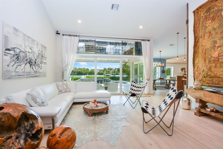 Welcome home... to an exquisite property that defines beauty, comfort, and elegance within the exclusive and historic coastal community of Hypoluxo Island. Overlooking the tranquil waters of the Lake Worth Lagoon and the oceanfront mansions of Manalapan, this large 90' x 350' property provides total privacy with lush natural landscape and expansive water views from nearly every room. Every aspect of this property was created with the Florida lifestyle in mind, including Hurricane rated impact glass windows throughout. Fully remodeled in 2017, this spectacular 4 bedroom 3 bath home will capture your heart with the warmth of natural light and sun kissed wood-beamed ceilings, open floor plan, covered lanai, and newly paved patio with saltwater heated pool/spa reflecting the true essence of