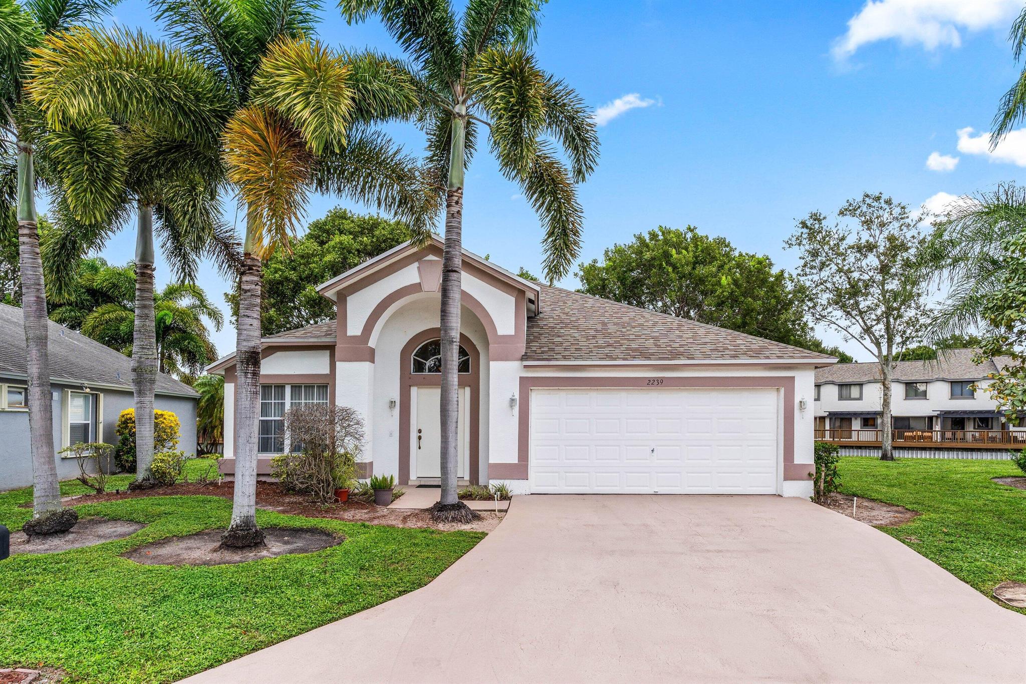 ALL AGES WELCOME!  Enjoy serene lake views from this beautifully maintained 3-bedroom, 2-bathroom home with a spacious 2-car garage. The split open floor plan features vaulted smooth ceilings and stylish new tile flooring with updated baseboards throughout. Major systems have been thoughtfully upgraded: roof replaced in 2020, air conditioning in 2022, and water heater in 2015--offering peace of mind and energy efficiency.  Nestled in a gated community, this home offers unbeatable convenience--just minutes from schools, the public library, Publix and Bodegon grocery stores, local dining, parks, Palm Beach International Airport, Wellington Mall, Wellington Hospital, and easy access to both I-95 and the Turnpike. The amenities for everyone to enjoy. 2 pet allowed no size or weight restriction