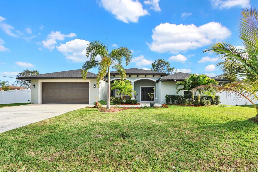 Stunning 2023-built home located on a spacious 1/3 acre corner lot in the heart of Port St. Lucie. This beautifully designed 4-bedroom, 3-bath residence with a 2-car garage offers 2,345 square feet of modern living space with an expansive open-concept layout that seamlessly connects the living, dining, and kitchen areas perfect for both everyday living and entertaining.The chef-inspired kitchen is the centerpiece of the home, featuring a large center island with ample seating, abundant cabinetry, generous counter space, and clear sight-lines to the main living areas. Large windows and sliding glass doors flood the home with natural light, creating a bright and welcoming atmosphere throughout. A desirable split-bedroom floor plan provides privacy, with ceramic tile in the main living areas. Step outside to your private outdoor retreat, complete with a sparkling in-ground pool and a fully equipped outdoor kitchen ideal for hosting gatherings or enjoying Florida's year-round outdoor lifestyle. The expansive yard is enhanced by mature fruit trees, while the sprinkler system on well water adds convenience and efficiency. Additional features include energy-efficient solar panels, a spacious indoor laundry room, and full impact windows and doors for peace of mind. Ideally situated near shopping, dining, schools, and major roadways, this home offers both comfort and convenience. A rare opportunity to own a nearly new, thoughtfully upgraded home with exceptional indoor-outdoor living in a highly desirable location.