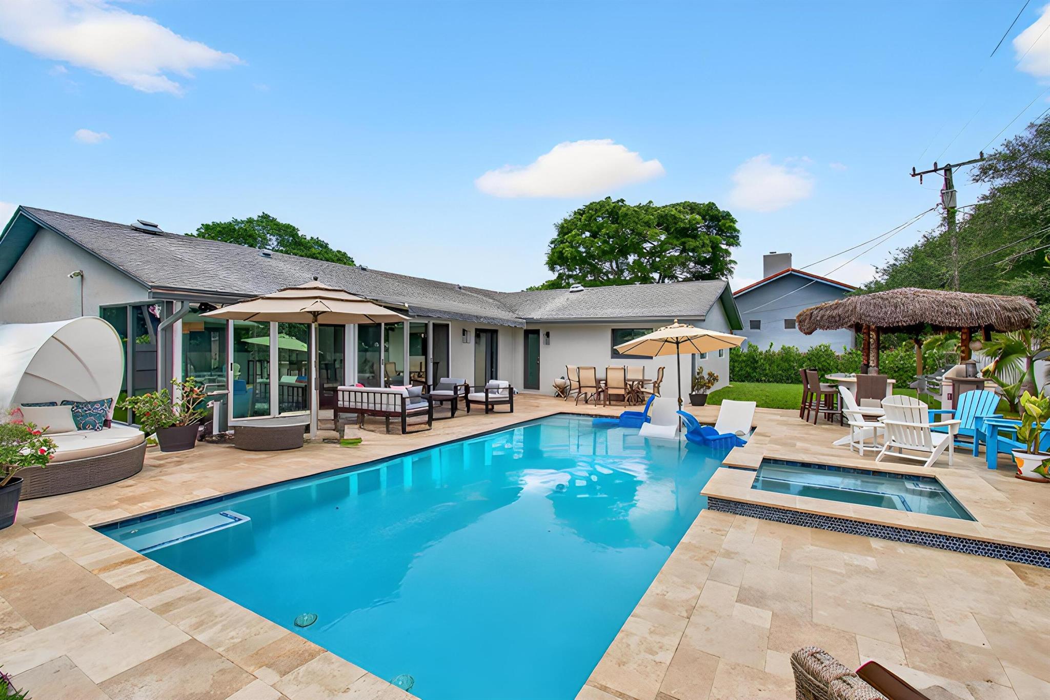 Live Every Day Like You're on Vacation!This fully renovated home feels like a private resort, featuring a stunning backyard oasis complete with a summer kitchen, tiki bar, oversized pool, hot tub, and plenty of extra space for entertaining or relaxing. The custom tiki bar includes a built-in grill, refrigerator, wine cooler, TV, speakers, and ambient lighting, creating the perfect setting for gatherings or quiet evenings. Inside, the home boasts a chef's kitchen, two spacious living rooms, a dedicated office, and a beautiful sunroom that overlooks the tropical backyard retreat. Whether you're hosting guests or enjoying peaceful moments alone, this home offers the ultimate getaway experience every day.