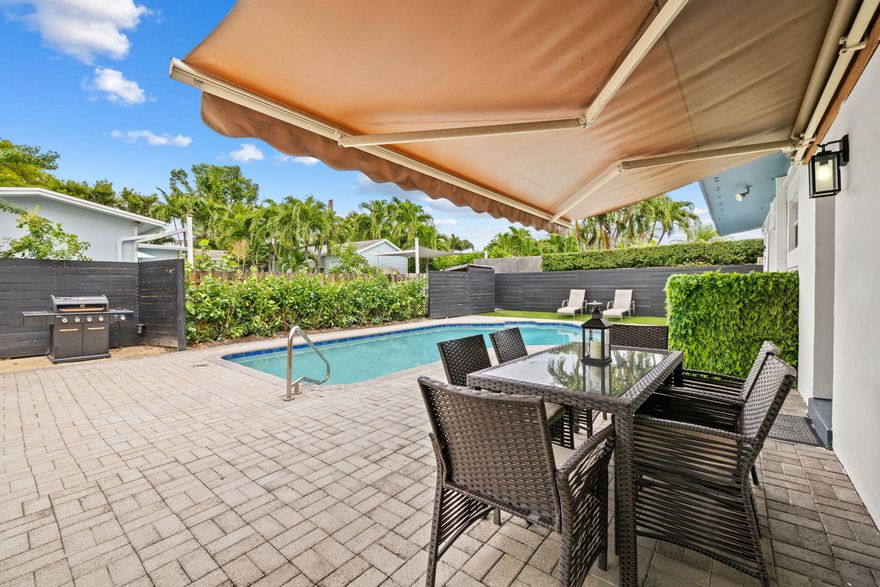 Step into easy, relaxed Wilton Manors living in this beautifully updated 3BD/2BA pool home where classic terrazzo floors, refinished in 2025, meet modern comfort, with a 2022 roof. Natural light fills the open living spaces, creating a warm and inviting atmosphere from the moment you arrive. Outside, your private backyard retreat invites slow mornings and effortless evenings with a resurfaced pool, fresh pavers, lush landscaping, artificial turf, and newer fencing for peace and privacy. A covered carport with Tesla charger and oversized shared  storage  shed add everyday convenience. This is a home that feels as good as it looks.