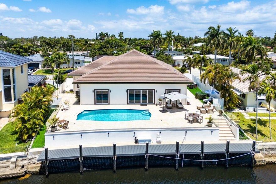Built in 2023, this exquisite waterfront residence invites you to BRING YOUR BOAT and experience elevated coastal living. Welcome to this stunning, waterfront, single-level residence located on the picturesque King Fisher Waterway in Deerfield Beach's highly coveted neighborhood of The Cove. This designer-inspired 3 bedroom/3.5 bathroom home blends contemporary comfort with timeless coastal elegance, offering 2,356 square feet of thoughtfully designed living space - and is available fully furnished and turnkey for off-season enjoyment.

Step inside to find an open concept layout with a split floorplan, ideal for both privacy and entertaining. Each bedroom features its own en-suite bath, creating a perfect retreat for family or guests. Driftwood style ceramic tile flows throughout along with 12-foot ceilings and beautiful water views, enhancing the airy beach inspired ambiance.

The chef's kitchen boasts a 6-burner gas range, island seating for three, marble countertops, and stainless appliances overlooking the main living and dining areas with seamless connection to the outdoor spaces. Whether you're hosting a gathering or enjoying a quiet evening, you'll appreciate the numerous areas inside and out designed to relax or entertain. 

The Primary Suite is a true sanctuary, complete with serene water views, a King-Sized bed and a luxurious marble shower. 

Step outside to your private waterfront haven featuring an oversized, heated, saltwater pool, with Southern exposure inviting all-day sun and relaxation. Nestle into one of the many areas for relaxation or sun-bathing while enjoying waterfront views via the glass-enclosed perimeter. 

Boaters will enjoy the newer 75-foot seawall and boat dock with electric wired, ideal for a 30-foot boat. Enjoy direct ocean access with just one 15-foot fixed bridge (approx. 14 ft. clearance at low tide, 8 ft. at high tide), giving you effortless passage to the intracoastal and beyond. 

Additional highlights include a full-house generator, outdoor shower, impact windows and doors throughout, security system, low-maintenance landscaping and close proximity to beach access with Downtown Deerfield Beach's restaurants and shops, all a stone's throw away. This waterfront retreat is your perfect Summer getaway to the best of South Florida's coastal lifestyle.