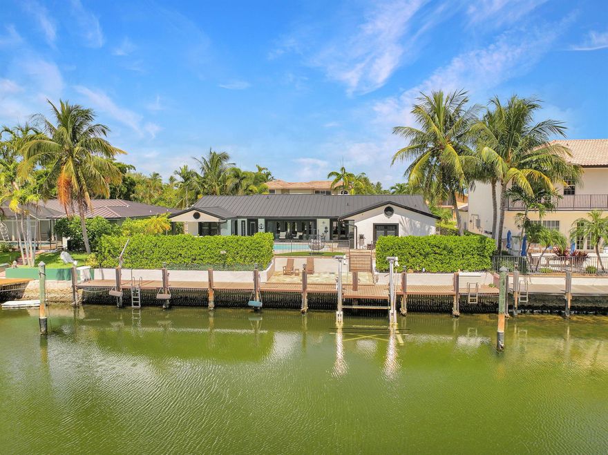 This beautifully redesigned estate in Venetian Isles offers 90 feet of waterfront and a private dock, ideal for those who desire the ultimate in coastal living. Highlights include dual primary suites, elegant marble and modern porcelain tile flooring, refined millwork, plantation shutters, and soaring ceilings. French doors in every room create a seamless indoor-outdoor flow, opening onto expansive terraces that embrace the waterfront setting.