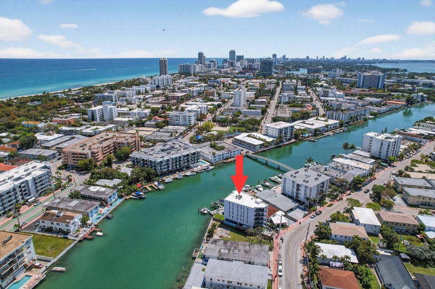 Welcome to 8125 Crespi Blvd #2, a truly rare waterfront offering in Miami Beach's coveted North Beach neighborhood. Set within an intimate boutique building of only four residences, this exceptional home enjoys the privacy and exclusivity of a full-floor layout, with each unit occupying its own floor in an elevator building. The result is a lifestyle that feels elevated, private, and distinctly refined—more like a waterfront retreat than a typical condominium.  Beautifully renovated, the residence blends clean modern design with a relaxed coastal elegance. Expansive open-concept living and dining spaces are filled with natural light and framed by wide canal views, creating a seamless connection between the indoors and the water beyond. Multiple balconies invite you to enjoy morning coffee, ocean breezes, and the tranquil backdrop of boats and sparkling water, while the generous scale of the interiors makes the home feel both luxurious and welcoming.  The designer kitchen is as functional as it is striking, featuring white shaker cabinetry, stone countertops, stainless steel appliances, a dramatic black tile backsplash, and water views that turn everyday moments into something special. Thoughtful details continue throughout, including beautiful wood-look flooring, elegant cove lighting, in-unit laundry, and stylishly renovated bathrooms that give the home a polished, move-in-ready feel.  A versatile den adds another layer of flexibility and value, easily serving as a fourth bedroom, private office, media room, or guest retreat. The spacious bedrooms offer comfort and privacy, while the overall layout is ideal for both quiet enjoyment and effortless entertaining.  Outside, residents enjoy covered parking, a shared waterfront deck, and boat dockage available at an additional cost—perfect for buyers seeking a true waterfront lifestyle. Just as appealing is the location: tucked along the water yet only a short walk to the ocean at Miami Beach, and moments from the local restaurant scene, neighborhood cafés, and the charm that makes North Beach so desirable.  8125 Crespi Blvd #2 offers a rare combination of boutique exclusivity, full-floor privacy, modern renovation, and walkable Miami Beach waterfront living. This is luxury with a more intimate, authentic point of view.