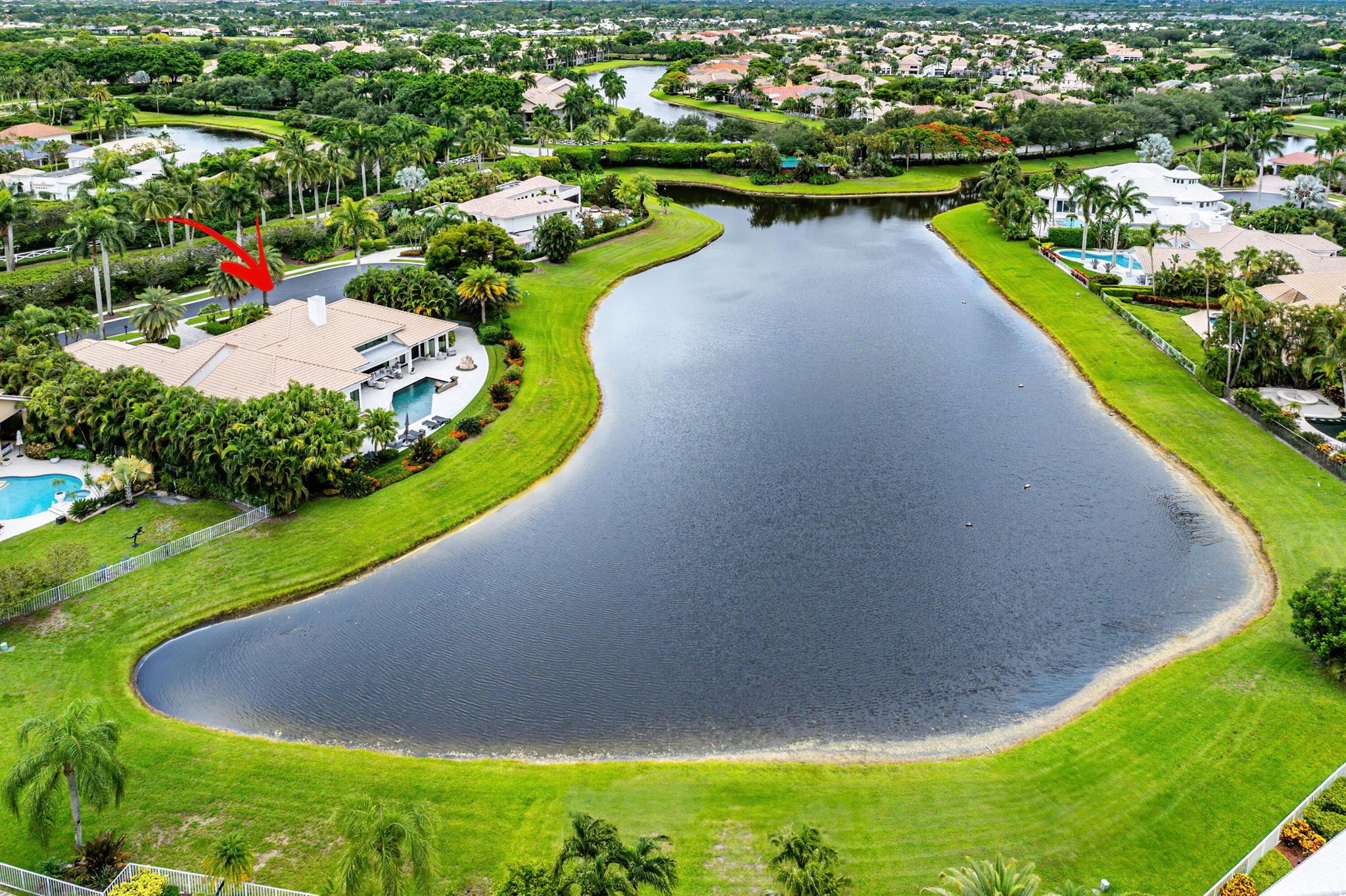 Perched on a rare, oversized lot at the end of a quiet cul-de-sac, this remarkable estate commands some of the most breathtaking, panoramic lake views in all of The Polo Club. A stately entry and private circular driveway set the tone for the grandeur that awaits beyond the doors. Upon entering, soaring volume ceilings and expansive interiors immediately impress, with natural light cascading through large-scale windows and glass doors that frame the mesmerizing water vistas. Designed with intention and distinction, this updated home features a generous floor plan accented by custom, bespoke finishes that elevate each room into a gallery-worthy statement. Throughout the home, thoughtfully selected light fixtures function as sculptural works of art, adding depth, warmth, and