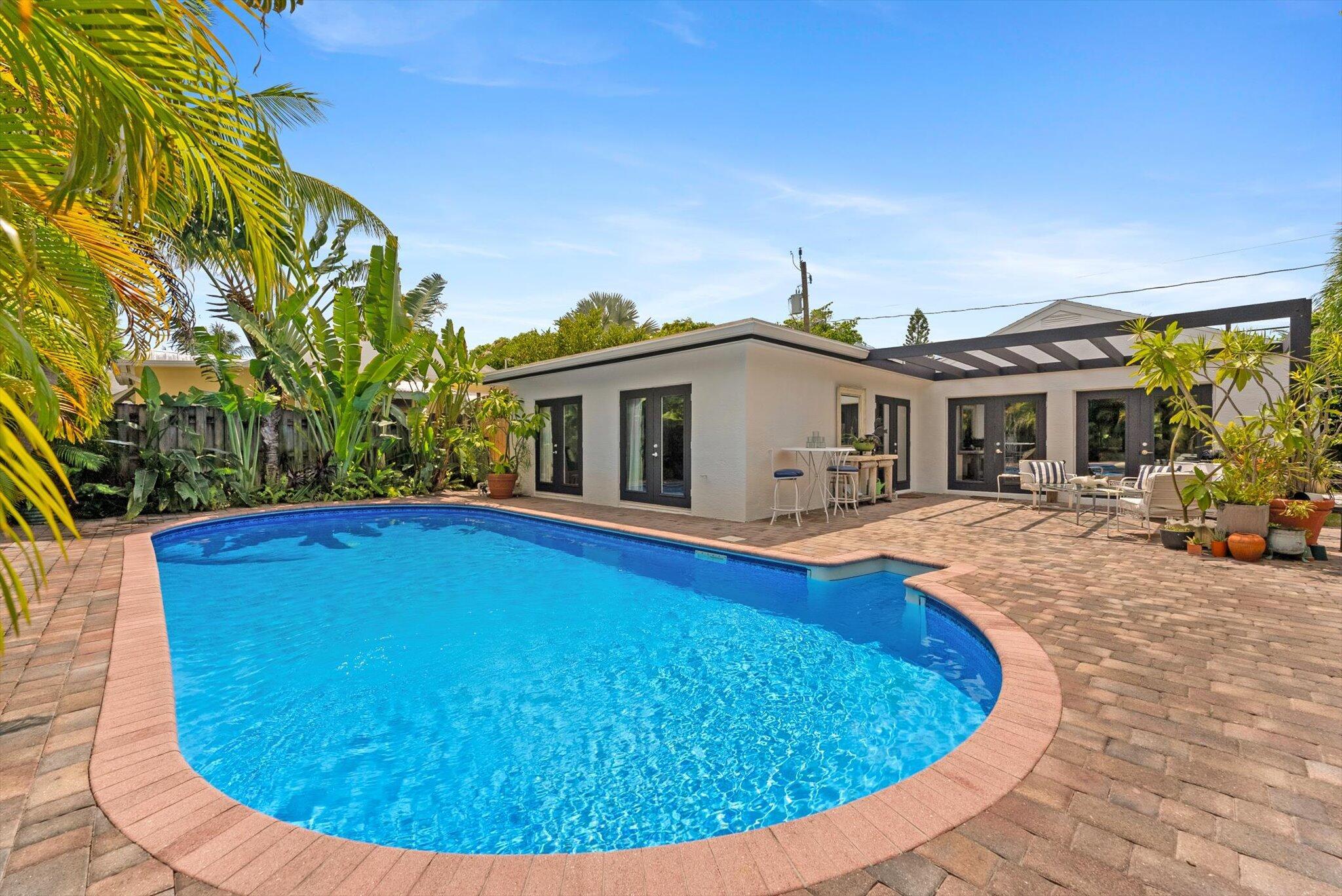 Step into your own private oasis. Enter through a lushly landscaped courtyard and discover an oversized sun-drenched pool, the centerpiece of an outdoor space designed for both stylish entertaining and quiet relaxation. With a seamless flow into the airy, open-concept living and kitchen areas, this home captures the best of South Florida indoor-outdoor living.Inside, natural light pours through large impact glass doors, illuminating the spacious great room. The chef's kitchen is a true showstopper featuring high-end stainless-steel appliances, granite countertops, abundant cabinetry,This move-in-ready home is centrally located just minutes from the vibrant downtown Lake Worth Beach, world-class beaches, the luxurious EAU Hotel, West Palm's cultural attractions, & Palm Beach Island