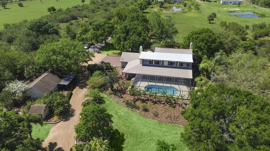 Make your mooove to this one-of-a-kind 7.65-acre ranch estate with a screened-in POOL, NEWER 2022 ROOF, a fully equipped IN LAW SUITE, 6-horse stable, stockable pond, 2024 and 2020 AC units, storage shed, TWO wells, a water softener system and MORE! This size property is perfect for your fruit trees, cows, goats, treehouse, place to park your RV, boat, etc. The MAIN house has 4BD 3BA, an updated kitchen and two cozy fireplaces and NEW 2025 flooring. The master suite overlooks the property and has a private balcony to enjoy your coffee and a spa-like master bath. There are plenty of windows throughout the house to open for airflow in cooler weather and enjoy natural light. The built-in jacuzzi and oversized screened-in pool (30x14) area overlook the pond perfect for enjoying