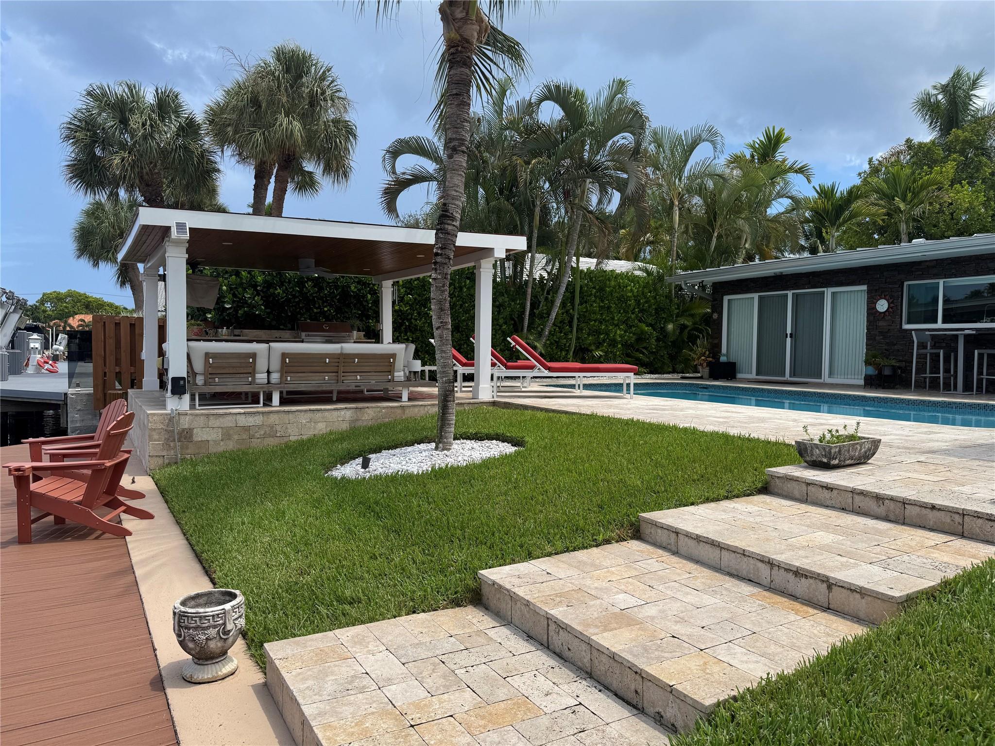 What a great waterfront home. Located on 80 feet of water frontage. This 4 bedroom and 3 bath home has been beautifully updated. Open kitchen with all new appliances. Hurricane impact windows and doors. Over sized 2 car hurricane impact garage door. Plus the garage is air conditioned. If you love to entertain, you will love the back yard with all the landscaped lighting. The pool has been updated with new heater/chiller. Great out side summer kitchen and gazebo. New 10,000 lbs boat lift and new Trex dock and under water lighting. The roof was replaced in 2017. Very quiet street and close to shopping, restaurants and the ocean. This is a must see.