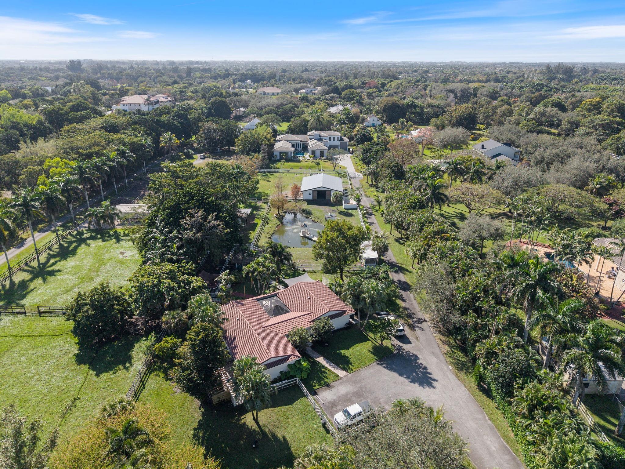 Welcome to the epitome of country living. This exquisite residence sits on 2.78 acres in the heart of Sunshine Ranches. It is very private, quiet and serene interior lot. The gated entry opens up to the 2/2 guest house (renovated in 2019). The 2 bedrooms are massive, perfect for guests and family. The oversized rear deck overlooks the gazebo on the pond, chicken coop, extended tiki hut, and horse grazing area. The courtyard style main house was built on the rear of the property in 2023. It has 3 bedrooms, 6 bathrooms, a gym, his and her offices, an expanded dining room, a modern gas fireplace, wine wall and bar, a nine seat 3 level theatre, a massive game room that holds a pool table, ping pong table, Foos-ball table, PAC Man table and still has ample seating. Piped ready for extra bath.