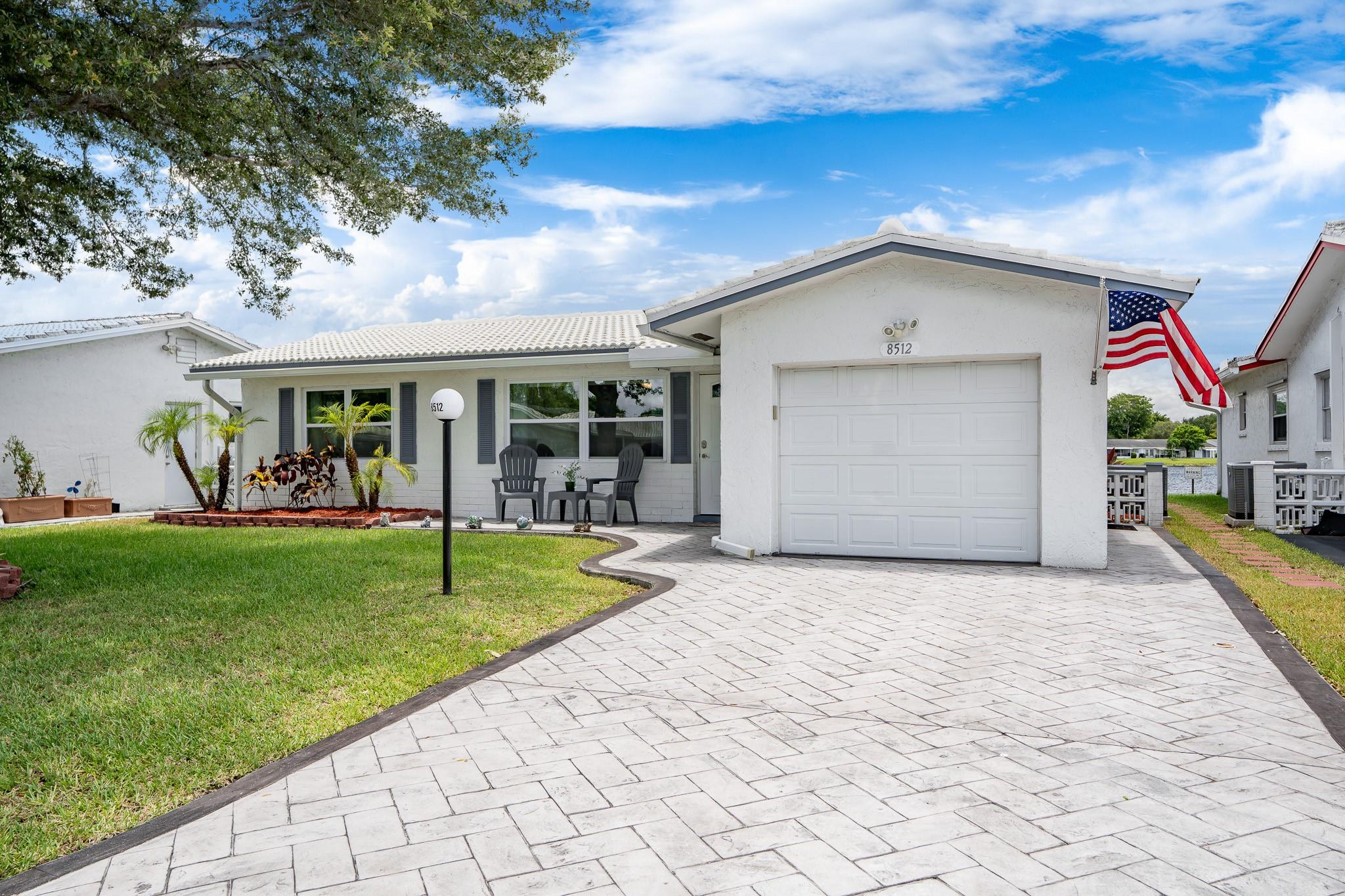 Lauderdale West, 55+, SPECTACULAR LAKE FRONT (AMAZING VIEW); 2/2 W/Garage, ALL UPDATED dream home! Full IMPACT protection, Crown Molding, PLENTY of CLOSET SPACE, porcelain tile thru-out, gorgeous custom kitchen w/top of the line appliances incl W/D, updated electric panel, updated bathrooms W/OVERSIZED SHOWER, AC (2019), ROOF (2018), double wide - STAMPED CONCRETE driveway, screened rear patio, too much to list, this is a like new home! No disappointments! Low maintenance includes Cable TV & Wi-Fi, repair/replace tile roof, 2 heated pools, 2 spas, saunas, 3 Tennis courts, fully equipped fitness center, billiards, ping pong, private library, professional shows, clubs, community bus at your doorstep to shopping and more. Near to shopping, restaurants etc. A must see!
