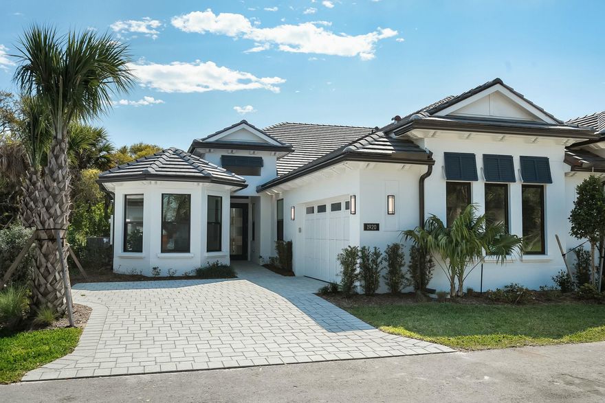 The Seabreeze Grande, a 4-bedroom, 3-bath villa with over 2366 finished square feet, offering the ultimate in-island living. Nestled in a charming Florida setting surrounded by lush landscaping, this home boasts an exquisite pool including 3-24'' sheer descent waterfalls and a built-in wrap-around bench surrounded by lush landscaping, perfect for embracing the carefree island lifestyle. The covered patio is screened in with rail fencing around the pool area. And a retractable screen on patio. Exceptional finishes include solid core interior doors, Arhus Classic Blanco wood-look tile flooring, volume ceilings, bay window in bedroom 2, quartz countertops, under-cabinet lighting, high-end Cafe appliances, Bar area with a beverage refrigerator. With the added option of a 4th bedroom or den
