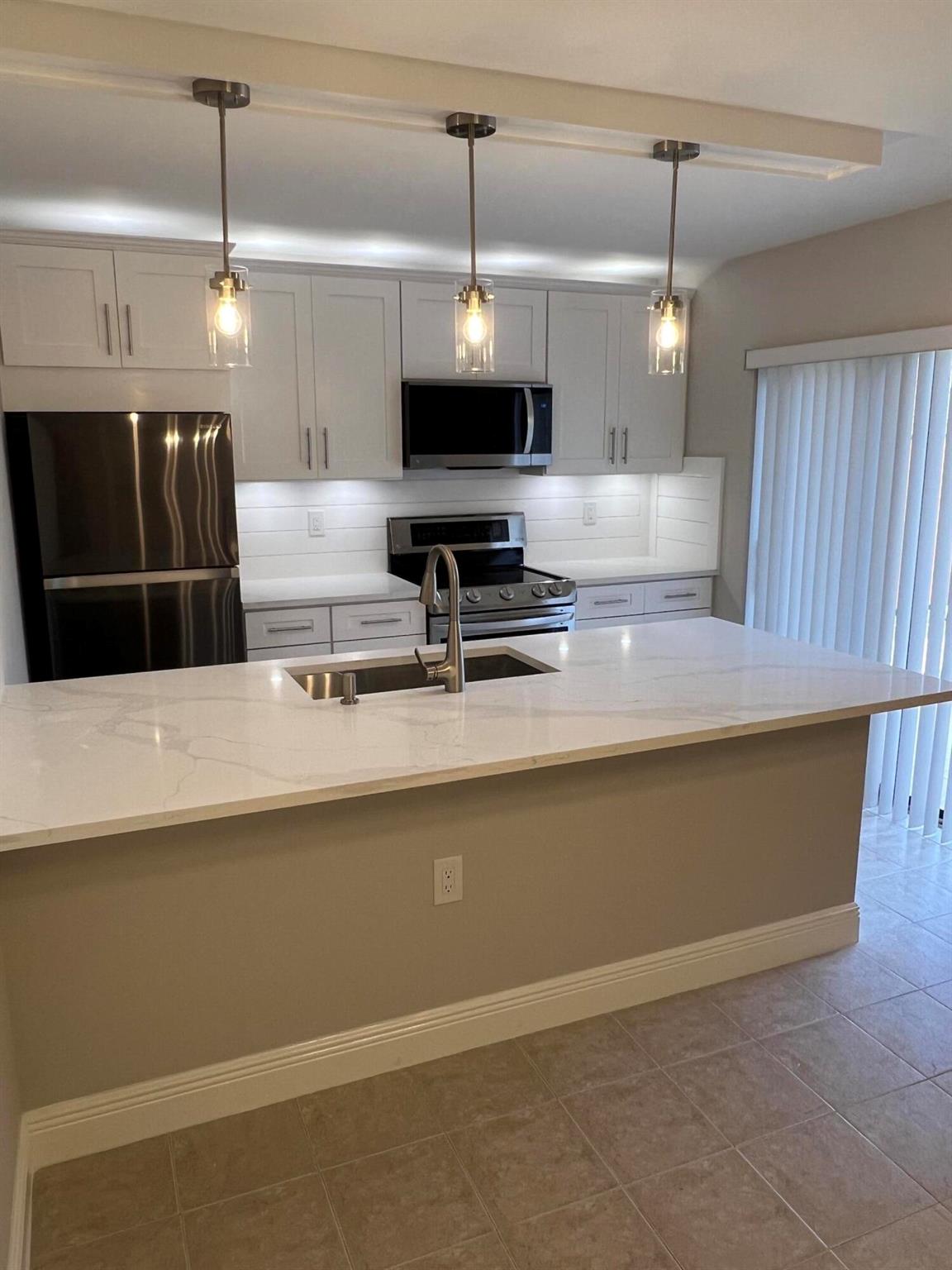 Newly remodeled River North townhome features a new kitchen with Ship Lap, SS appliances, white cabinetry and beautiful quartz counter tops. All bathrooms have been updated. Tile and wood plank laminate flooring on first floor with Berber carpet upstairs. Accordion hurricane shutters. Private courtyard patio with storage unit and designated parking space. Don't miss the opportunity to live near Jupiter Beach, Juno Beach pier and Bluffs shopping plaza!!
