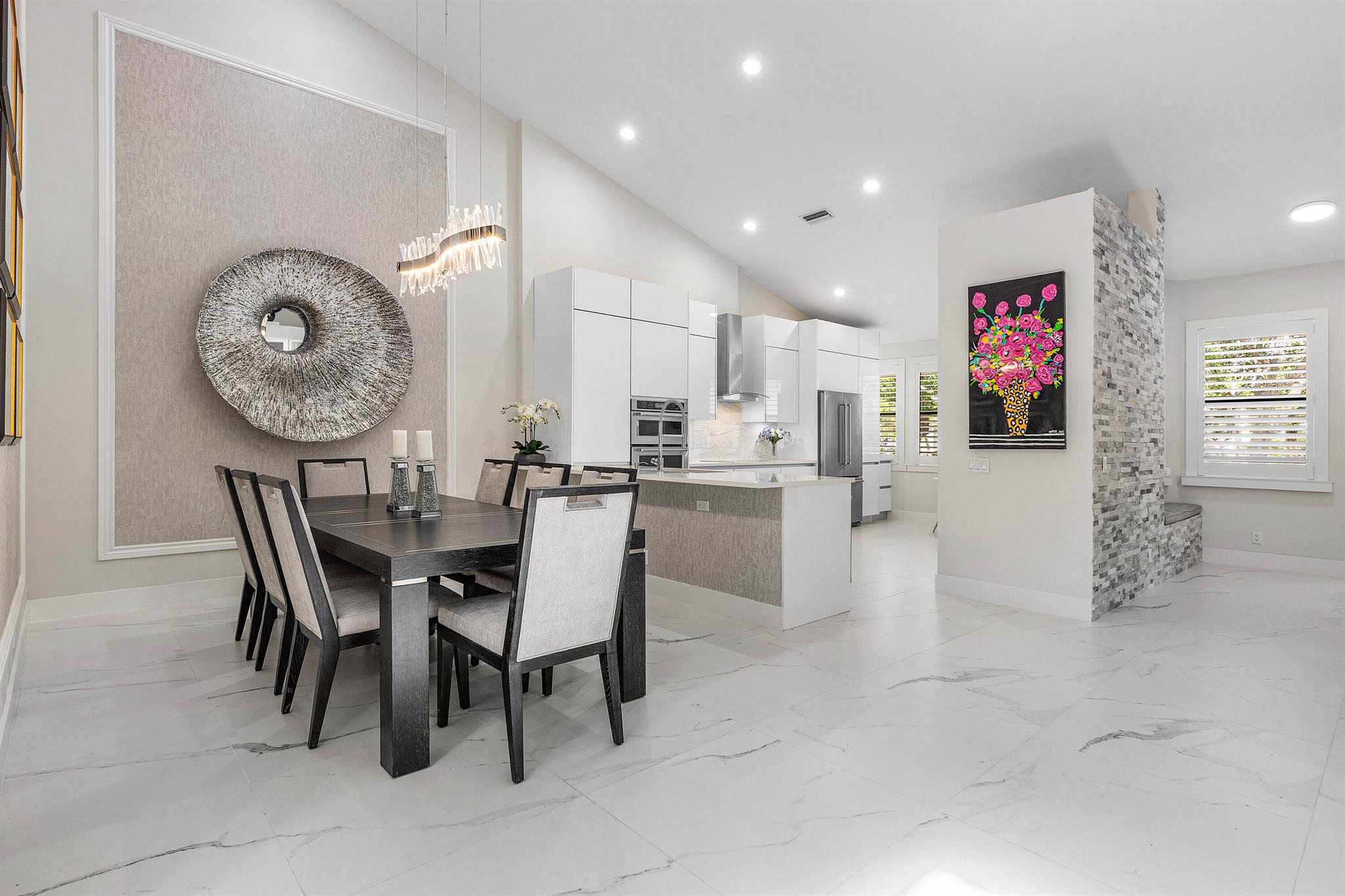 This stylishly renovated penthouse condo blends modern finishes with thoughtfully curated design. Upon entry, choose to ascend the stairs or take your private elevator to the main living level. Impressive volume ceilings, custom wall treatments, built-ins, and cohesive design details flow throughout, creating an inviting atmosphere. The open-concept layout seamlessly connects the gourmet kitchen appointed with sleek finishes to the dining area, perfect for hosting. A bright living room extends to an expansive enclosed balcony, offering extra square footage and the ideal setting to enjoy peaceful water views from this elevated retreat. A chic, separate family room provides a secondary space to relax in style. The dramatic primary suite features a generous walk-in closet and a spa-inspired