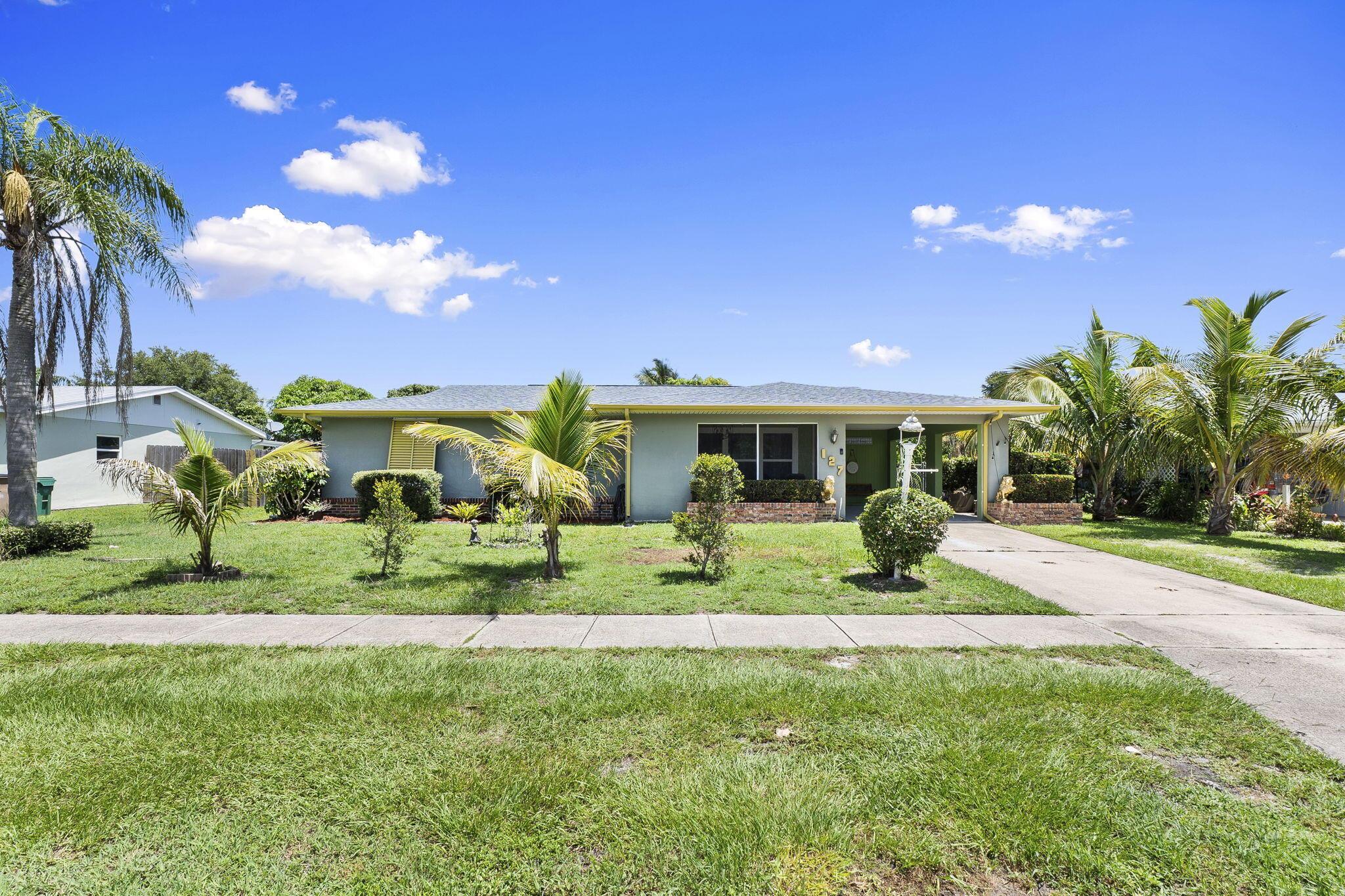 Located within Port St Lucie without the high property taxes aka county only taxes!! New Roof 2024. AC 2023. HWH 2024. All appliances including the washer/dryer are new or just a few years old. Full storm protection with impact glass & panels. Kitchen has been updated with a fresh backsplash, granite, soft close features & stainless steel appliances. Updated bathrooms. There is an additional office space and full size laundry room with plenty of room for additional storage. Fully fenced in yard abundant in banana, east Indian mango, ackee, coconut, soursop, sweet sop/sugar apple & avocado trees. Located off of St. James you have easy access to I-95, Fort Pierce & St Lucie West shopping & dining options.