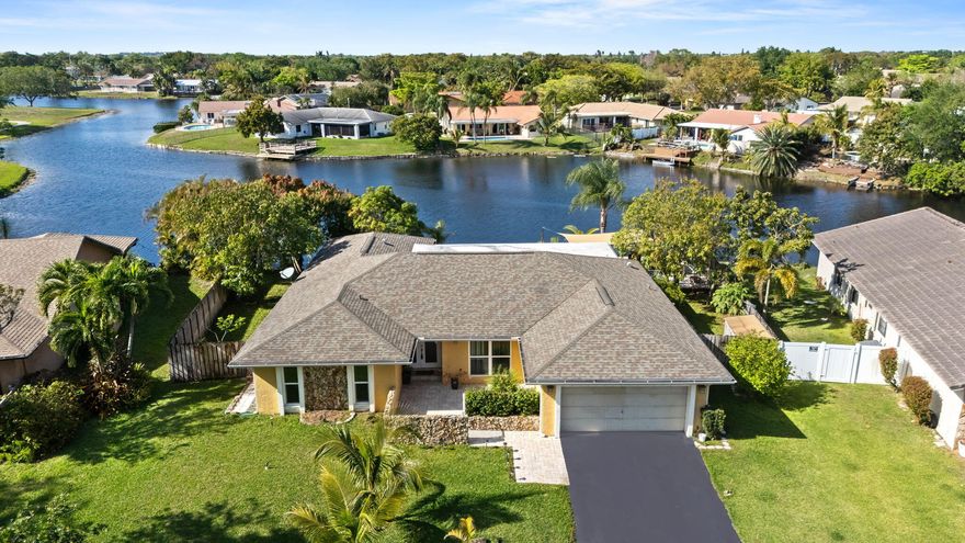 Beautiful, cared for family home with expansive lake view overlooking jacaranda lakes family park, complete with concrete dock!This home features fruit trees, travertine paved pool deck, propane tank that runs many items inside and out and safety fences. Roof 2020, A/C 2022, H20 Heater 2022. Master bath revovated, 2nd bath shower renovated. Kitchen has solid wood cabinets and black granite tops. Stainless Kenmore Elite appliances. Kitchen island and stove vents outside. Separate laundry and pantry. 2 car garage with extra electrical outlets and pull down stairs as well as second refrigerator and chest freezer included. Hurricane windows on part of home and shutters for other areas. Screened in porch for rainy days and open deck with pergola overlooking serene lake on nice days!