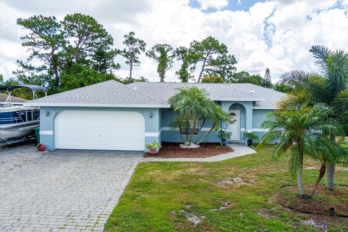Beautifully maintained 3-bedroom, 2-bath, 2-car garage CBS home on a quiet street just off Crosstown Parkway in the heart of Port Saint Lucie! This move-in ready home features a new roof, low-maintenance tile and vinyl flooring throughout, and a desirable split floorplan offering privacy and functionality. Enjoy multiple living areas, including a fully enclosed Florida room under A/C--ideal for a home office, gym, or lounge--and a screened-in porch overlooking a fenced backyard with no rear neighbors, thanks to a drainage canal. A covered hot tub, which stays with the home, provides the perfect space to relax. Additional highlights include an indoor laundry room. Don't miss this well-located home offering comfort, versatility, and peace of mind