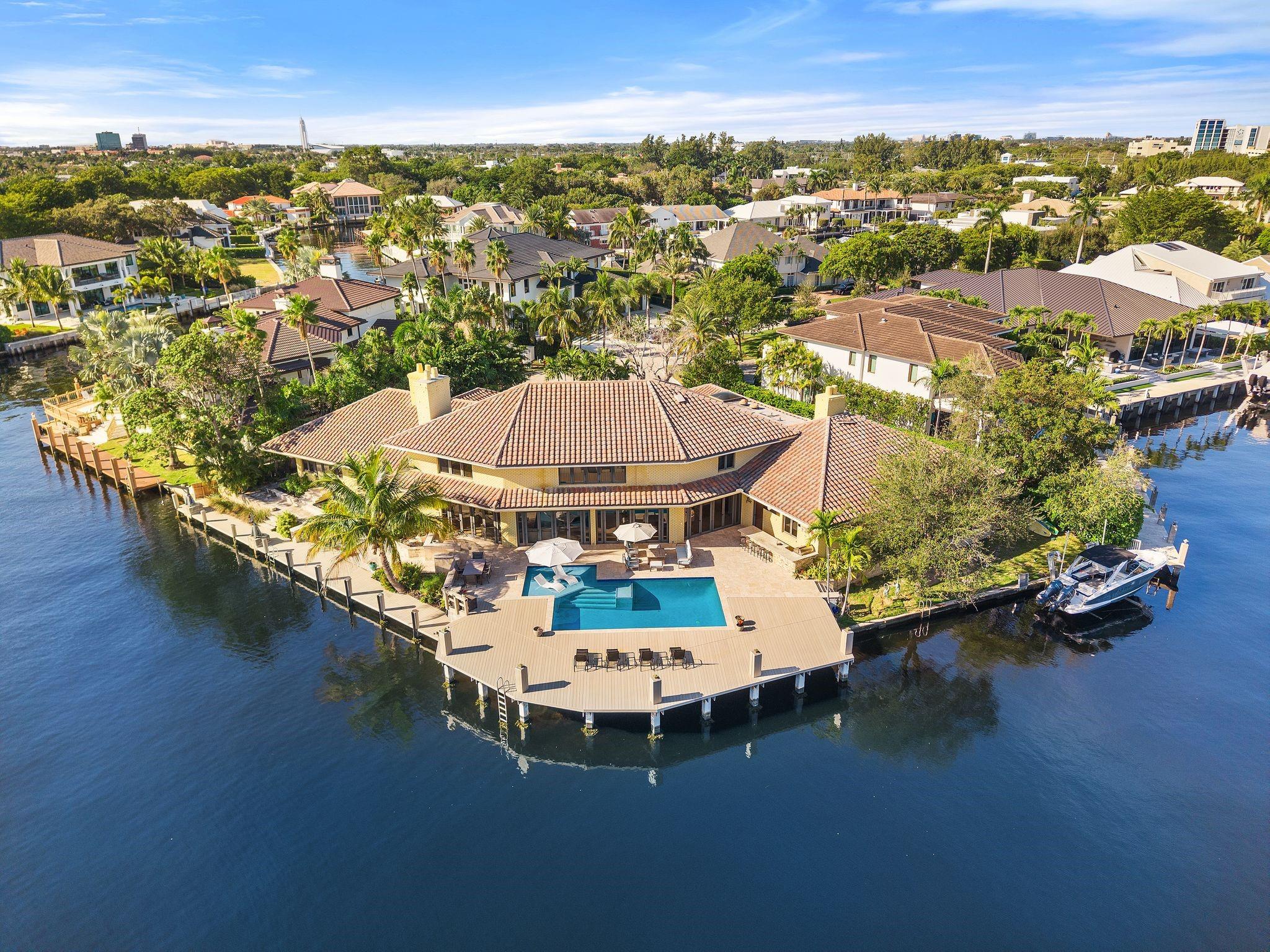 Welcome to this spectacular point lot estate located in the prestigious, private gated community of Bay Colony. A yachter’s dream boasting 240’ of waterfrontage, boat lift, wide canal and turning basis, this home can accommodate multiple yachts or catamarans. It is a perfect family home spanning over 7,300 sq. ft. with 5 beds and 7 baths and is located in close proximity to the premier private schools of Pine Crest School, Cardinal Gibbons and Westminster Academy. Primary suite encompasses the entire second story with sauna, private office, and separate sitting room. Enjoy the expansive water views from the renovated heated, saltwater pool and patio area that includes a built in summer kitchen. On just over 1/3 of an acre this is arguably one of the best lots in all of Fort Lauderdale