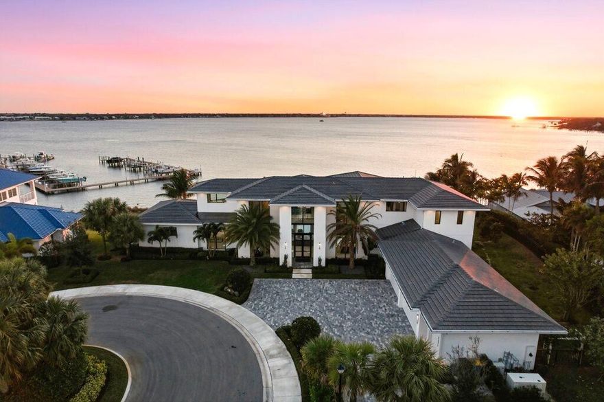 One-of-a-kind legacy custom 2022 built home surrounded by spectacular waterfront views atop an elevated .97 acre property.   Designed for family and entertaining living the home features endless amenities.  This 2 story home provides 6,651sqft under air and a spacious 9,350 sqft  under roof.  5BR, Den, 5 full bath and 2 half baths, Club room, loft and elevator.  Four (4) car  air conditioned garage plus golf cart garage.  A 50' dock with 20klb cradle lift is located at the community marina includes water and electric.   The main floor entertainment layout is open flow from the generous living room with fire place / dining/ bar / architectural temperature controlled wine cage that holds 1,134 bottles to the gourmet  kitchen with large island, appointed with Wolf and Subzero appliances and butler pantry with additional dishwasher. The indoor flows to the outdoor air conditioned entertainment space with complete outdoor kitchen / bar / dining and fireplace that can be enclosed with automated roll down screening.  An oversized vanishing edge salt pool with spa has two heat pumps and LED lighting,  perfect to watch the sunset from.  Spacious sides and back yard includes a putting green and is completely fenced. The second floor includes a large club room and loft area with outdoor balcony.   Additional specifications are included in documents for this listing.