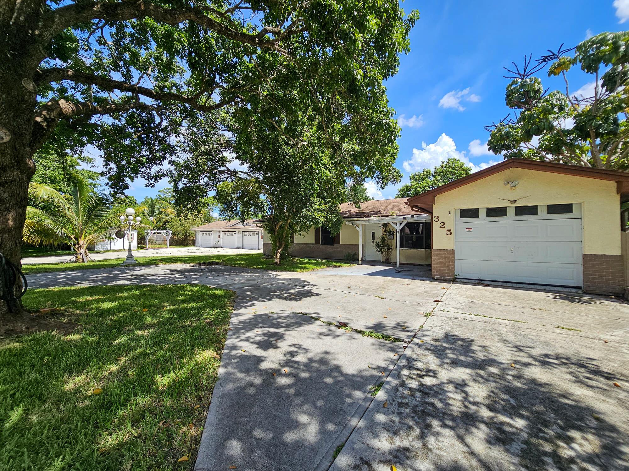 Investor special in Port St. Lucie! This property sits on 2 lots and includes a 3 bedroom, 2 bath single-family home with 1,352 sq. ft. of living area, a second building with 1,296 sq. ft., and an oversized workshop/garage with shelving and workbenches. The main home offers a classic layout while the additional structures provide endless potential for storage, hobbies, or future conversion. A true fixer-upper/handyman special, this property needs work but has great potential for investors or buyers looking to add value. Conveniently located near schools, shopping, and major highways.