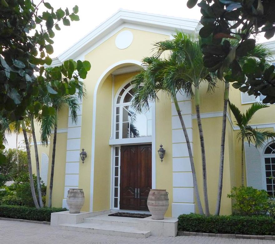Elegant Island Drive 2-story house with Intracoastal views of West Palm Beach. The house features 5 bedrooms, 7 baths and 1 half bath. It also has beautiful covered loggia, with high ceilings, marble floors and fireplace. Beyond the pool is a dock.