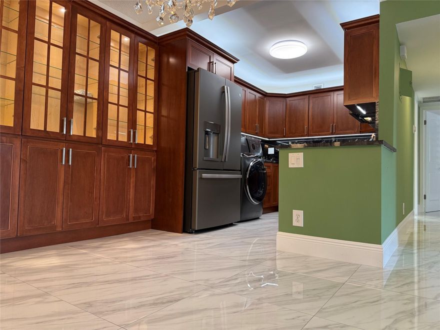 Exquisite, fully renovated residence just steps from Wilton Drive’s dining, boutiques, and nightlife. This designer home features 24x24 porcelain tile, a stunning chef’s kitchen with rich cherry cabinetry, slate GE appliances (2025), and a custom lighted display cabinet in the dining area. The in-kitchen GE Profile washer/dryer offers ultimate convenience. Impact windows give peace of mind. Custom white plantation shutters thruout, spacious closets with organizers, newer A/C, and parking in front of the unit. Enjoy the Florida lifestyle relaxing by the Resort pool and BBQs. Have your next gathering in the  elegant clubhouse with party kitchen. This home is available fully furnished if desired. No leasing 1st yr owned. Rent limit of 10% with wait list. Reqd cable/internet fee of $92.20.