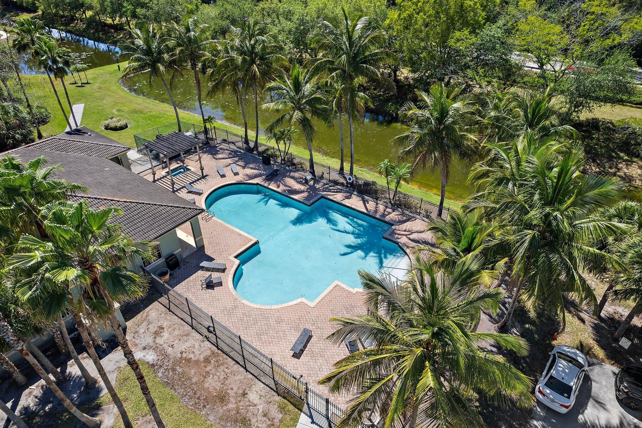 Welcome to Kensington of Royal Palm Beach, a beautifully maintained gated community offering resort-style living surrounded by lush, mature landscaping and a tranquil waterfront habitat. This spacious 3-bedroom, 2-bath corner unit is flooded with natural light, thanks to its thoughtful layout and abundance of windows. Designed for both comfort and functionality, the open floor plan provides generous living spaces perfect for relaxing or entertaining. Enjoy a host of amenities including a sparkling pool and hot tub, clubhouse, fitness center, tennis courts and scenic walking trails throughout. The included 1-car garage is a rare bonus, offering secure parking along with ample space for laundry and additional storage. Peaceful, private, and conveniently located in the heart of Rpb.