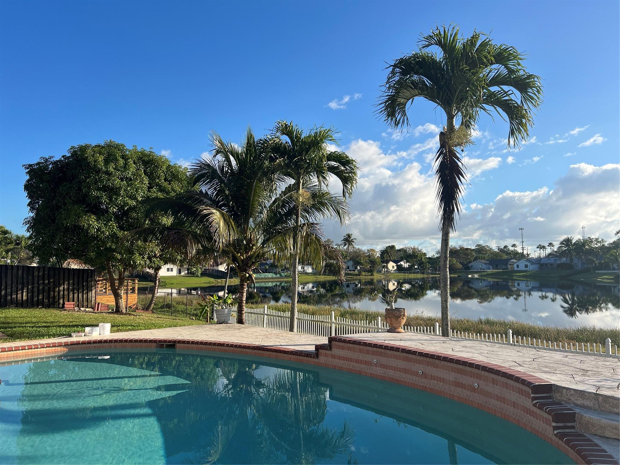 SERENE LAKE FRONT LIVING. RARE OPPORTUNITY to rent a home with both pool & lake in the desirable community of Flamingo Gardens in Cooper City with excellent schools. 3-bedroom, 2-bath home featuring 1,807 square feet of living space with pool and lake. This home boasts new flooring, new paint, newly paved circular driveway for extra parking, beautiful Spanish tile roof. The kitchen is equipped with brand-new stainless steel appliances including a LG refrigerator, Samsung dishwasher & new microwave. Lots of natural light & views of the pool & lake from almost every room of the home.