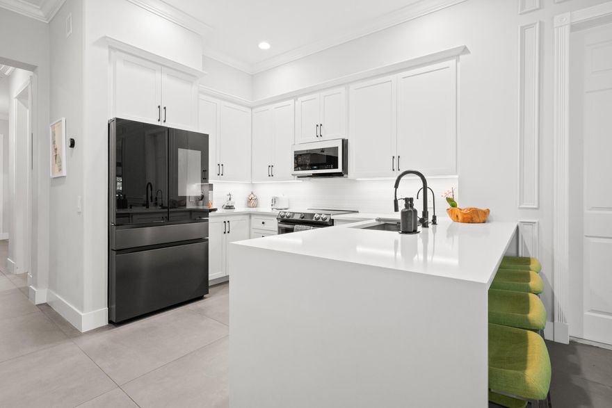 Beautifully Maintained Single-Story Tuscany - Abacoa Residence with Designer Upgrades! This impeccably maintained single-story Tuscany home offers the perfect blend of comfort, style, and modern upgrades. Featuring an open and functional layout, the home includes a spacious primary suite with a large walk-in closet, two guest bedrooms, a full guest bath, and a versatile den—ideal for a home office or additional living space. The upgraded kitchen is a true centerpiece, showcasing sleek white quartz countertops, a custom European backsplash, upgraded cabinetry hardware, and a full suite of Samsung appliances—including an induction double oven range and a smart refrigerator with built-in screen and TV. Custom under-cabinet LED lighting with smart controls enhances both functionality and ambiance. Throughout the home, you'll find premium Italian 3x3 anti-slip cooling tile flooring (excluding the primary bath), custom crown molding, and 6-inch baseboards, creating a refined and cohesive aesthetic. The living room is elevated by a custom feature wall finished with European white tile, a built-in fireplace, and an in-wall high-end speaker system—perfect for an immersive entertainment experience. Additional highlights include: Whole-house water filtration system + under-sink reverse osmosis Smart home features including Ring doorbell, Nest thermostat, smart switches, and dimmers Upgraded Legrand tamper-resistant and GFCI outlets throughout UV light installed in the AC handler to help prevent mold buildup, Built-in floating office cabinetry with quartz countertops High-end chandelier and custom foyer pendant lighting Garage with hanging metal storage systems, Two elegant brass outdoor sconces. Step outside to enjoy a large, private fenced backyard backing to serene green space—offering exceptional privacy and room to relax or entertain. Ideally located just one mile from Main Street and Roger Dean Stadium, this home combines luxury upgrades with a prime location. A rare opportunity you won't want to miss