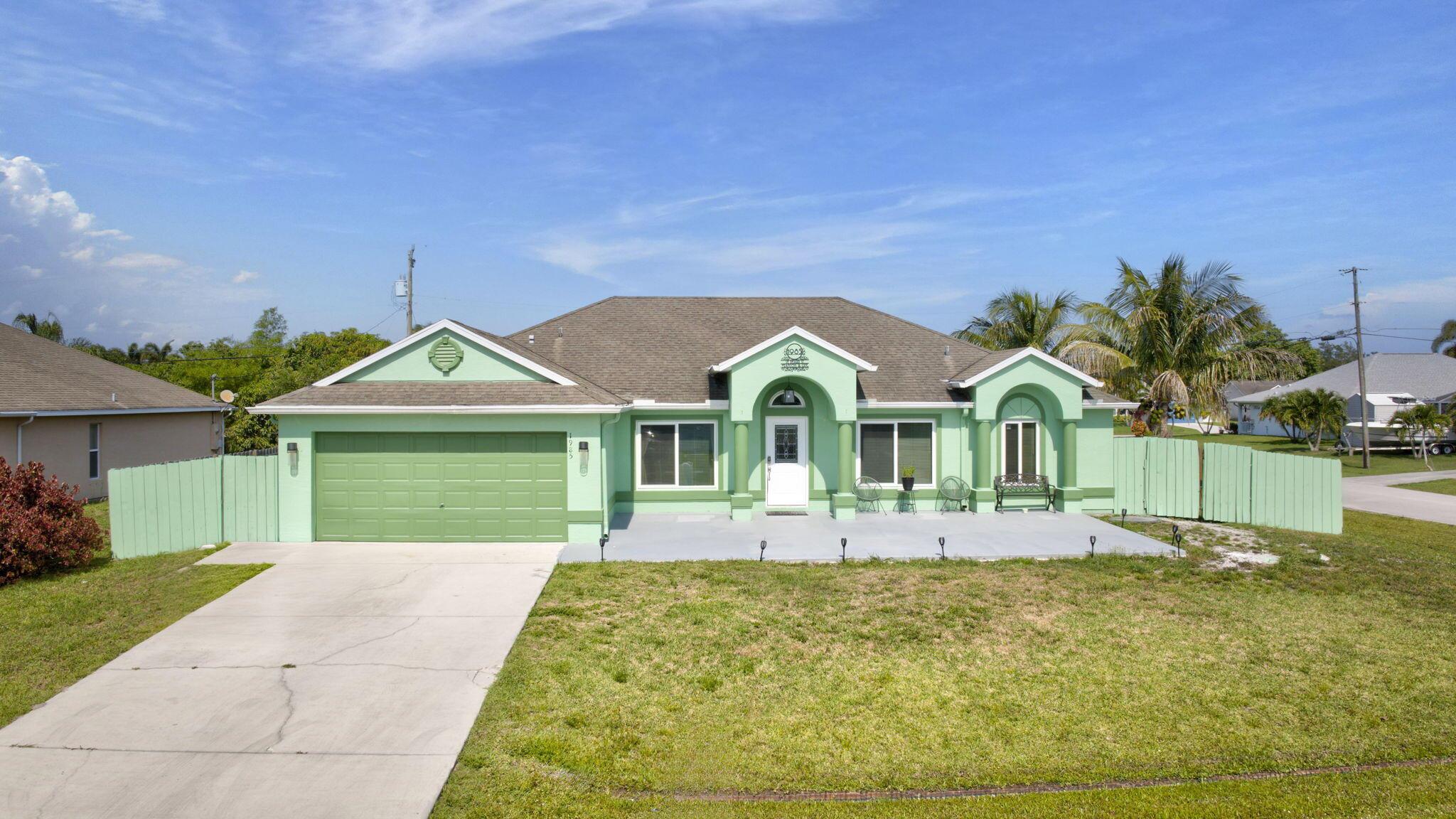 Spacious 4-bedroom, 2-bath, 2-car garage home on a large fenced-in corner lot in Port St. Lucie. Features include impact windows, elegant living and dining rooms, spacious family room, and a screened back patio. The main bedroom offers vinyl plank flooring, extra closet storage, and has en-suite bathroom with dual sinks, separate shower, and walk-in closet. Additional upgrades include a newer A/C, water heater, W/D, well cared for roof. The garden has mango, orange and coconut trees, a papaya plant as well as oregano herb garden! There is a a tool shed attached to the side of the building in the year as well. Easy access to Turnpike and I-95, minutes from the NY Mets Stadium, and centrally located between Orlando and Fort Lauderdale.