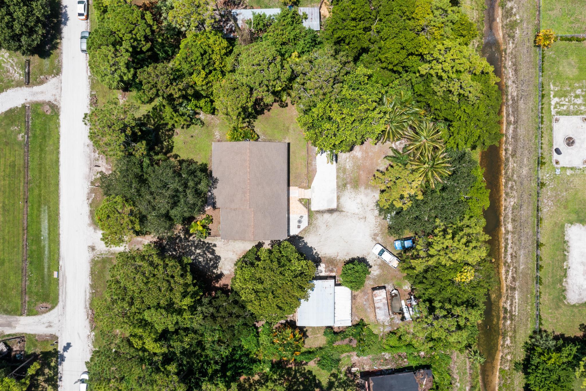 Custom built CBS Home on high & dry 1.28 acre that is fully fenced & gated in Loxahatchee. Best location. Right by the new Publix & great shops. * Paved roads the whole way & 62nd Rd N in front of this home will be completely paved any day now. This great home is Clean & Comfortable & has 1956 sq ft ac'd living area-3 large bedrooms + office/baby/den/4th, 2 baths & 35 x 12 Covered scr. patio. Central Vac. Extra storage & addl W&D hookup. 2 zone CAH 1 is 2 yrs w/ Blue light & the other is 11 yrs. Large rooms & great Closet space. Energy efficient home in summer highest Elec bill about $230. Canal in back offers extra privacy. Detached Steel Bldg which helps provide great storage for equipment, parking, & equipment etc. Roof new in 2012, & very good shape. Camera system.