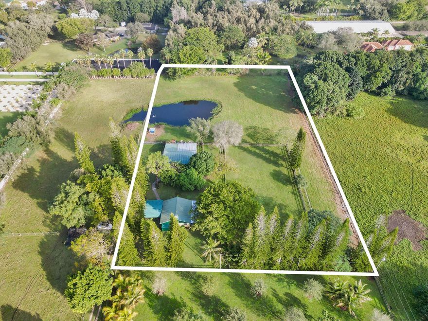 Welcome to this privately-tucked property, located in the quiet and prestigious Southwest Ranches community. It boasts a vast 2.5 acre lot with lush ackee, mango, and avocado trees, as well as livestock, and a natural pond. Home features tile flooring and a sleek metal roof w/the AC condenser recently being replaced. Ideal for those seeking luxury redevelopment opportunities or utilization of over 2 acres of land. The property includes a guest quarters with 1 bed/1 bath, a large garage, walk-in freezers, and a massive workshop—perfect for a variety of uses. Agricultural and homestead tax exemptions in place. Enjoy the added perk of being neighbors with one of the largest houses by living area in Florida. Don't miss the chance to make this exceptional property your dream home!