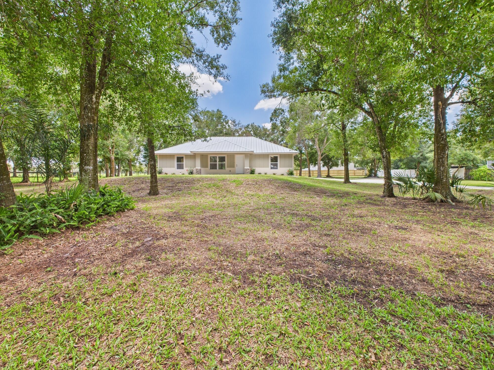 Brand new 3BD/2BA custom CBS home on 1 acre! Featuring a split floor plan with vaulted ceilings, open living & dining, and an island kitchen with butcher block countertops, custom tile showers, backsplash, and premium lighting. The exterior shines with a metal roof, impact windows, and stucco board & batten with stone accents. Relax on the spacious covered porches or gather around the custom fire pit under mature trees. Plenty of room for a shop, RV, or toys. Located on Okeechobee's east side--just 30 minutes to Fort Pierce. Not your run-of-the-mill spec home!