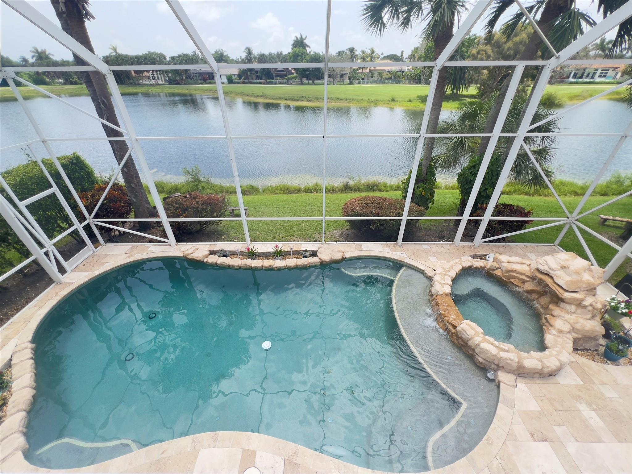 Welcome to this beautifully maintained 5-bedroom, 3-bathroom lakefront home with a new roof completed in 2024. This home is located in the Grove Place subdivision of the highly sought after Grand Palms community in Pembroke Pines. Enjoy peaceful water views from your screened-in pool and hot tub, complete with a tranquil waterfall feature. The expansive covered patio and open-air balcony provide the perfect spaces for outdoor entertaining or relaxing in privacy.
Inside, this spacious home offers a functional layout with generous living spaces, a 2-car garage, and many upgrades throughout. Original owner.
Don’t miss this opportunity to live in a gated golf course community with access to beautiful walking paths, and convenient access to I-75, shopping, and dining.