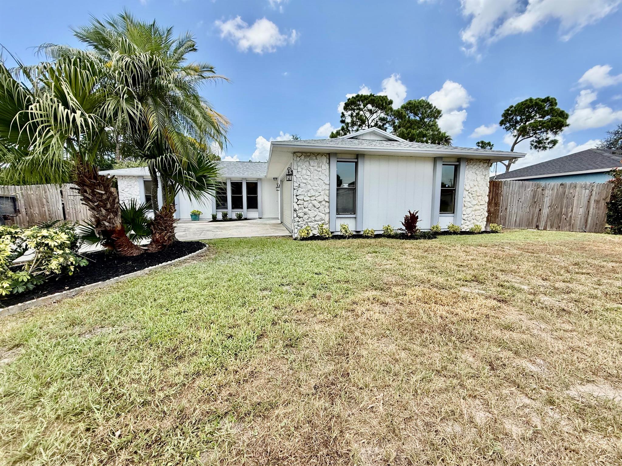 This stunning 3-bedroom, 2-bath, 2-car garage home offers the perfect blend of comfort, style, and location. Featuring a brand-new roof and luxury vinyl plank (LVP) flooring throughout, this home is move-in ready with modern upgrades in every room. Enjoy a spacious open floor plan ideal for entertaining, with a remodeled kitchen showcasing quartz countertops, stainless steel appliances, and contemporary cabinetry. Both bathrooms have been tastefully renovated with stylish finishes, offering a spa-like feel. Step outside to your private backyard oasis complete with a sparkling pool--perfect for relaxing or entertaining. Centrally located just minutes from St. Lucie West, shopping, dining, and major highways, this home checks all the boxes. Don't miss out on this incredible opportunity!