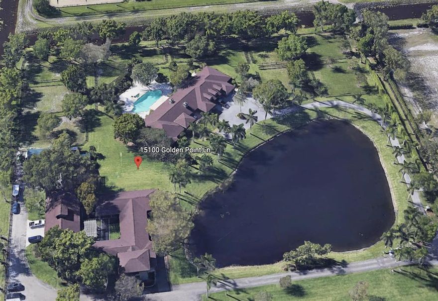 This gated Palm Beach Point property sits on 10+ acres and has it all! The main home features 5 bedrooms and 4-1/2 bathrooms. There is a 2 bedroom, 1 bath apartment attached to the house that comes complete with a full kitchen and living area - and has a separate entrance! The saltwater, heated pool is extremely relaxing. There are two barns, totaling 19 stalls. The 13-stall barn has tack and feed rooms, laundry room, a large hay room with roll down door for easy deliveries, an upstairs office with a full kitchen and full bathroom. The 6-stall barn has a groom's apartment, tack & feed room and washer & dryer. Each of the stalls in the barns has the fly spray system. Property also has a 256'x160' riding arena, large grass field and 21 paddocks!