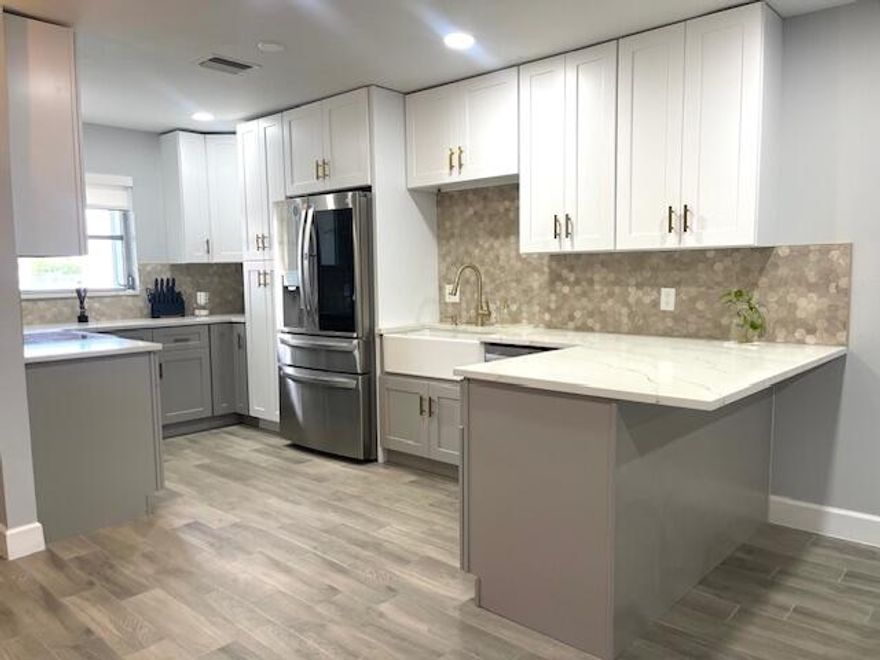 Beautifully renovated corner unit featuring a modern kitchen with quartz countertops, custom cabinetry, stainless steel appliances, and designer backsplash. Upgrades include new A/C, water heater, washer and dryer, new bathroom vanity, wooden tile style throughout, freshly painted, and shower panel, custom-built closet, brand new kitchen hood, accordion shutters. Very spacious and move-in ready with high-quality finishes throughout. Don't miss it!!!