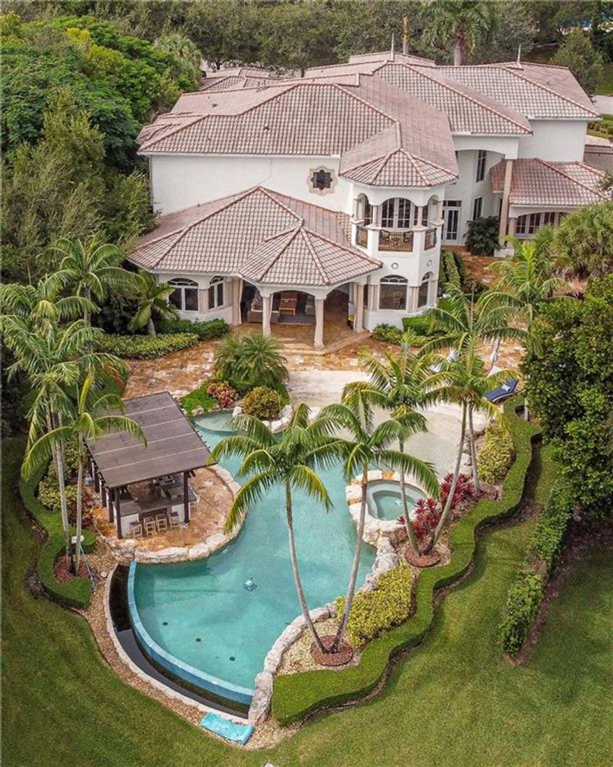 LUXURY LIVING in prestigious gated community: Windmill Ranch Estates. Perfectly situated on 1.60 acre lakefront lot, grand entrance, circular driveway, expansive porte-cochere & 4 car garage. 11,000+ sq ft, 7 bed, 6 baths & 3 half baths, office with custom cabinetry, gym, billiard rm w/ bar, media rm, loft, wine cellar, butler’s pantry, elevator, 4 new AC units & gas fireplaces. Gourmet chef’s kitchen, spacious island and top of the line appliances. Stunning staircase leads to primary en-suite w/ sitting area, dressing area & spa-like bath. Impact windows/doors throughout. Spacious outdoor entertaining areas, custom outdoor kitchen, & infinity-edge heated pool & spa.