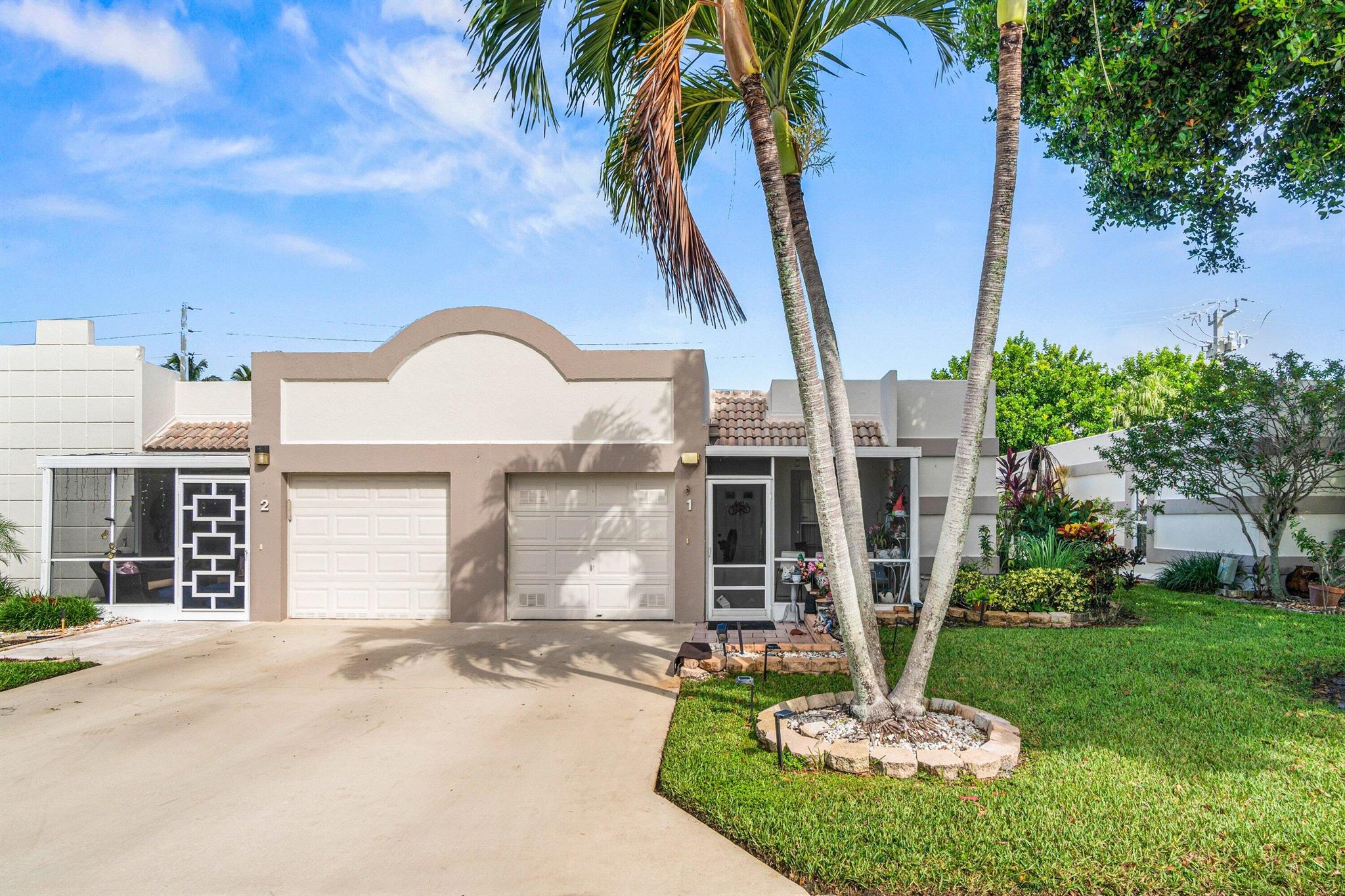 2/2/1 move-in-ready end-unit villa offers comfort, privacy, and convenience in one of the area's most desirable communities. Upgraded laminate flooring in the bedrooms, the interior feels bright and refreshed. The main living areas have beautiful white tile floors, recently acid-washed for a like-new finish. The spacious master suite includes a large walk-in closet, while the second bedroom offers two closets and an en-suite bath, perfect for guests or a home office. Additional highlights include crown molding, new light fixtures, and an interior laundry area. Enjoy outdoor living year-round with a tiled, screened front porch and an extended screened back patio overlooking a lush, private greenspace. The one-car garage and double driveway provide ample parking, with plenty of guest spots.