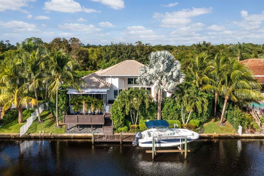 Your Dream Home Awaits! No expense was spared updating this gorgeous waterfront home located in the desirable gated community of North Passage. From the minute you walk in the door you are greeted by the coastal vibes of this light & bright single story home that offers 95' of waterfrontage & 9k lb boat lift, southern exposure and minutes to the Jupiter Inlet. The outdoor space is spectacular w/ heated hot tub & pool, waterfalls, travertine pavers 
& an amazing enclosed custom outdoor kitchen, w/ twin eagle appliances, big green egg, teppanyaki, fridge & more. Just outside is a gas firepit, & water feature.  Some of the interior features include a fully updated kitchen w/ white shaker cabinets, wolf induction range, double oven w/ steamer, warming drawer, & subzero refrigerator. See more. Adjacent to the kitchen is a butler Pantry w/ wine cooler/Laundry. The bathrooms have also been tastefully updated. The spacious master overlooks the pool, has 2 walk in closets built out by California Closets, plantation shutters and updated bathroom. There is also a custom Built-In home office w/ murphy bed that can be used as a 3rd/guest bedroom. This home has impact windows & doors (excluding passage door in garage & glass block in mstr. but those have hurricane protection. In addition to all the above there is an attached 2 car garage w/ extra parking on the extended paver driveway. Full house generator w/ inground 1,000 gallon propane tank. The list goes on! See Feature list under documents.