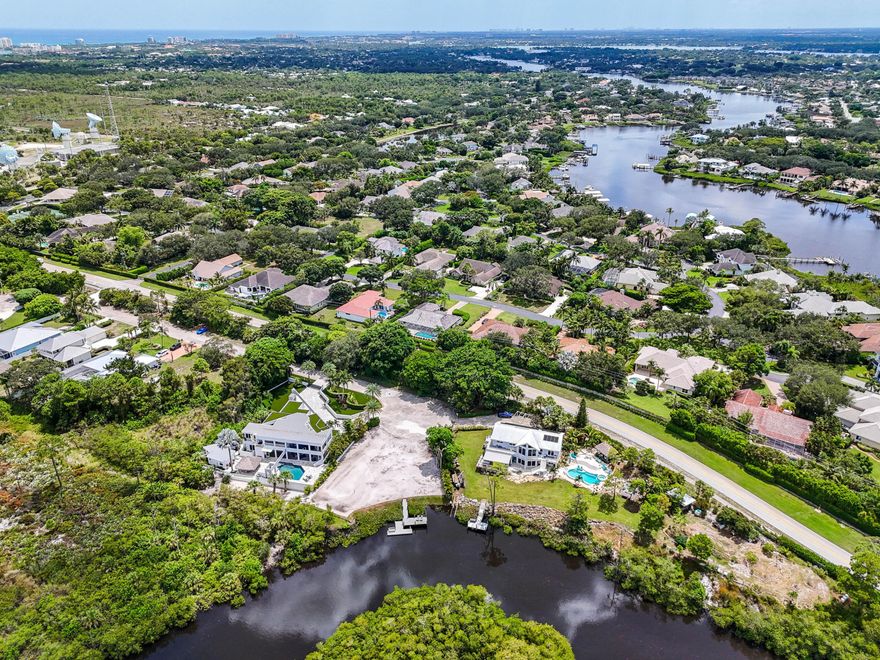 Nature abounds. One of a kind empty Riverfront Lot. Only cleared and filled lot on the river backing to JD State Park. Property sits elevated high & dry. Serene setting, Panoramic views, Landscape privacy hedges, and easy access to boating on the Loxahatchee River and beyond. Watch birds, Osprey, and the sunset on your new dock with 140 feet of breathtaking water frontage views. New pilings and composite decking with adjacent floating dock for jet skis, kayaks, and ease of entry. Build your winter retreat or forever house on this special lot. All utilities are already in place on the property... city water, city sewer, and electric. New County Line bridge reconstruction in progress with approximate 10' elevation for boat clearance.