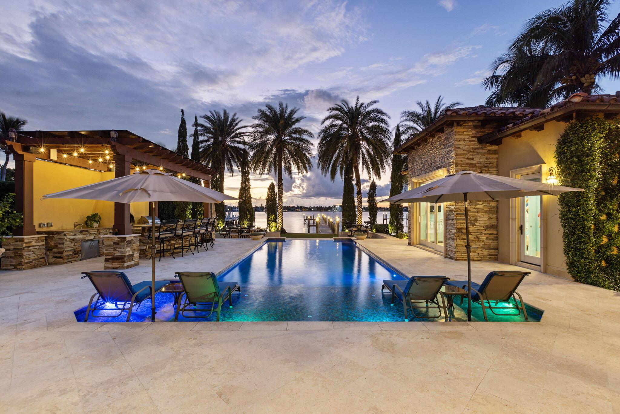 Presenting one of the finest properties on the entire island. We are now offering a truly unique opportunity to own a stunning waterfront Tuscan inspired estate on the wide water intracoastal. Expertly designed by award-winning architect Randall Stofft and crafted by renowned builder Rodney Sarkela, this custom-built masterpiece has never been on the market before and spans over 7,300 total square feet with a resort-like backyard. Spectacularly located just a few properties off the point of North Atlantic Drive in a no-wake zone setting on Hypoluxo Island. Perched with exceptional elevation, this residence commands direct west-facing intracoastal views offering sensational sunsets and an expansive backyard paradise with deepwater dockage to accommodate multiple water toys. Enjoy a heated