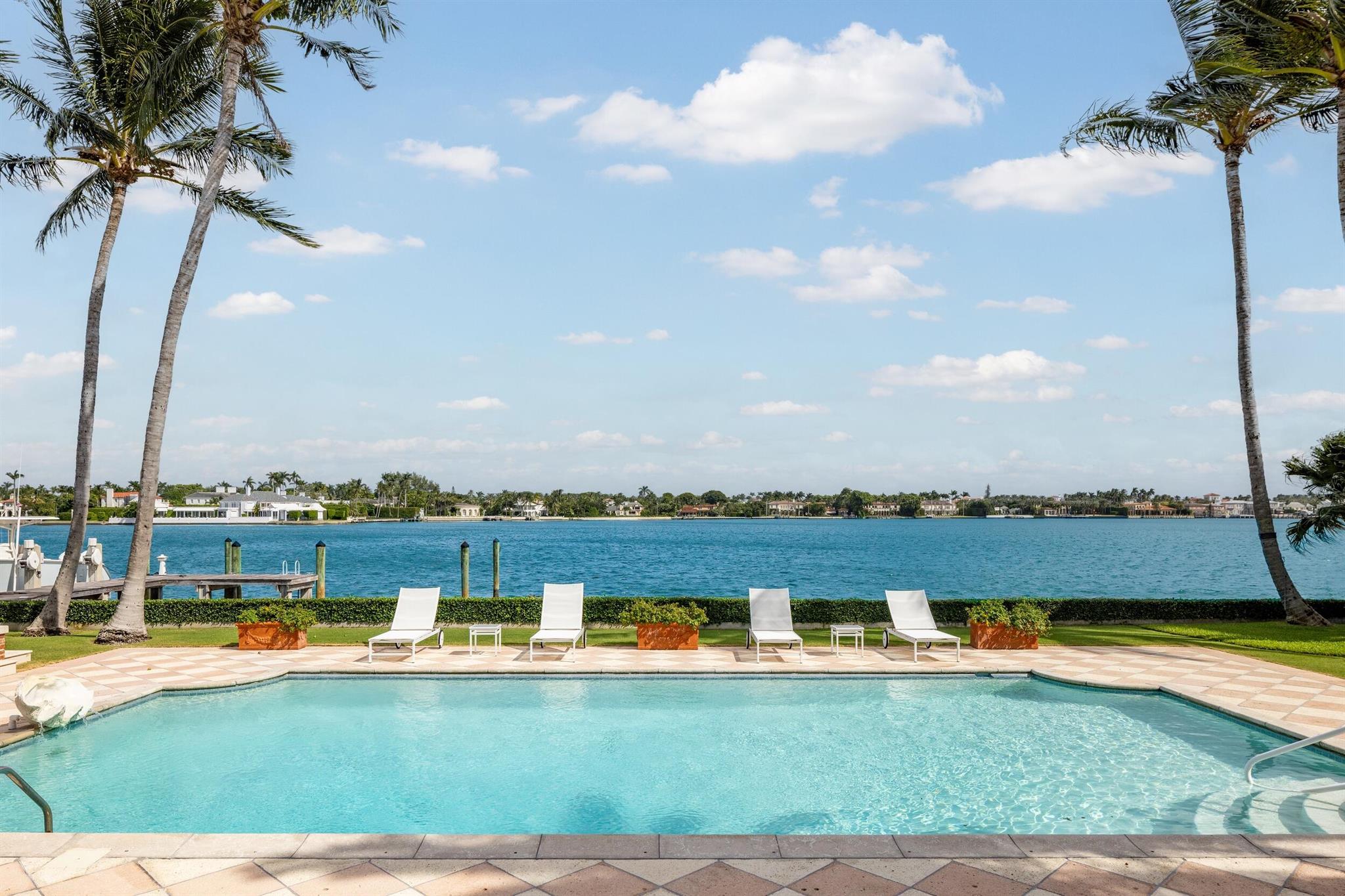 A remarkable and rare opportunity! This beautiful lakefront estate is nestled on an exceptional, oversized, east-facing lot on the coveted Everglades Island. Originally designed by renowned society architect Marion Sims Wyeth, the home features 7 bedrooms, 6 bathrooms, and 1 powder room, spectacular wide water views from nearly all main rooms, and boasts 175 +/- feet of direct Intracoastal frontage. Formal living room with fireplace opens to expansive, light-filled interior loggia that overlooks the swimming pool. Eat-in kitchen with large island and breakfast bar. Formal dining room with charming bay window. Breakfast room with beamed ceilings and pocket doors on either side for plenty of natural light. Paneled library with built-ins. Primary suite with large bath, dressing room, walk-in