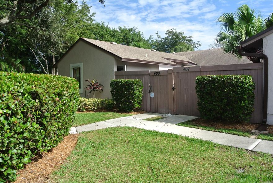 Unlimited possibilities and a great opportunity to own this charming 2/2 CORNER villa in outstanding location. This small quiet community, is set back and faces a nature preserve. Very private with many trees and foliage. Home has bamboo flooring thru out, split bedroom plan, walk in closet in primary, washer & dryer, hurricane panels and a huge enclosed paver courtyard patio with storage closet & shed. Very light and bright with 3 panel sliders in living room & bedroom. Roof is 4 years old. Two parking spaces as well as guest parking accommodate family and friends. Low monthly HOA includes community pool, lawn and landscaping, roof replacement, trash, reserves.