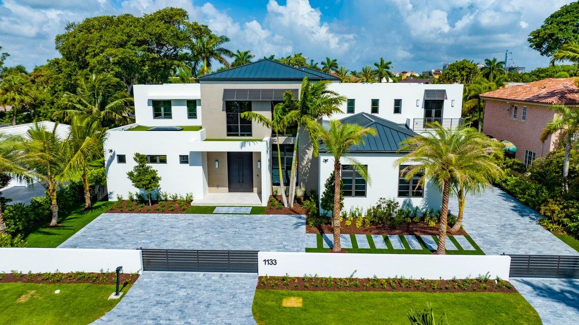 Commanding a grand sense of arrival, two gated entries, leading into a paver courtyard and a seperate driveway to a side-load three-car garage,introduce this chic 'Farmhouse Modern' estate. A pool entertaining area, showcases the lanai with a summer kitchen and cabana bath.The dramatic two-story foyer/reception hall, with a handsome floating staircase, reveals the chic two-story living room featuring a professional custom bar where a wall of double-tier glass windows and sliding doors provide views of the pool andgardens while capturing private tropical landscape. Adjacent are the open dining room that includes a built-in hutch and gourmet kitchen which also connects to the family room and lanai.
