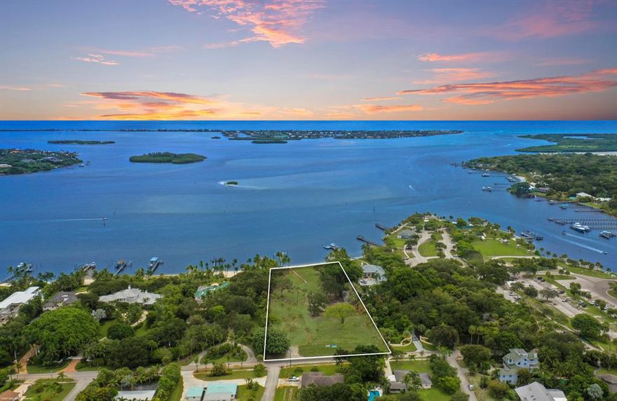 Incredible double lot with 250' of sandy beach and aqua blue inlet water on over three buildable acres with direct views of the Saint Lucie Inlet.  Elevation of 25' above sea level offer excellent panoramic views and near constant gentle ocean breezes. The property has abundant old growth southern trees strategically placed within the property and along the perimeters for maximum privacy.  Private waterfront is protected from waves and boat traffic by an inner sandbar. New over engineered ipe dock and boat lifts with electric and fresh water.  Much required site work has already been completed making it ''shovel ready'' which will save months of construction time. New irrigation well for landscaping on site.